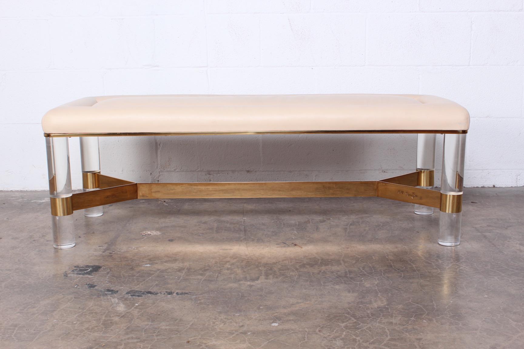 A large Lucite and brass bench by Karl Springer. Signed with original leather cushion.