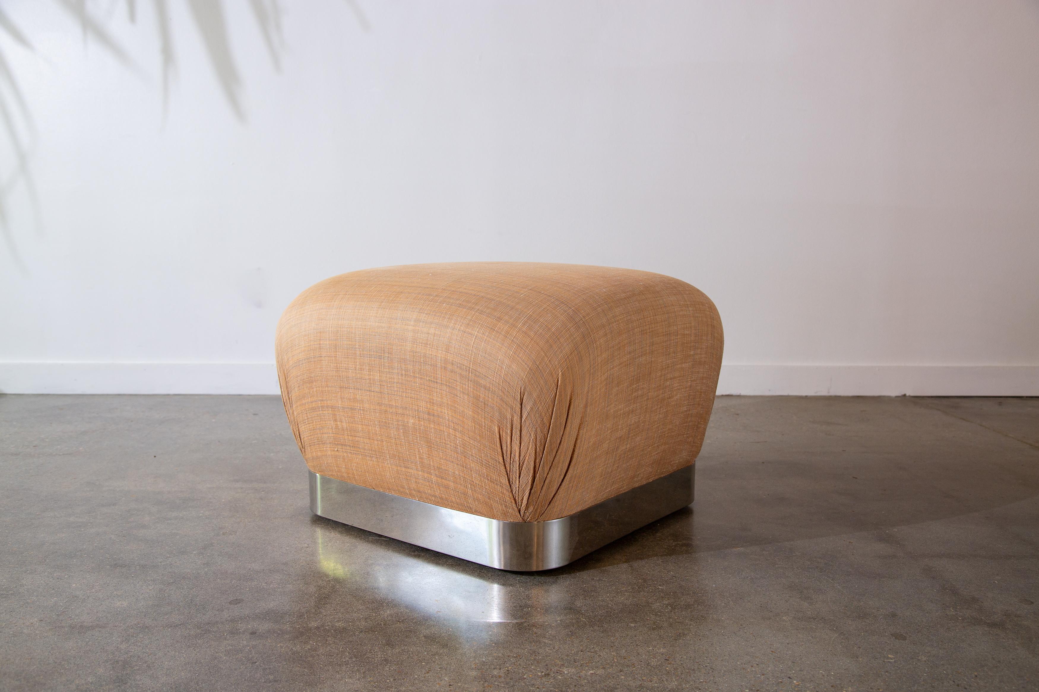A 1980’s large rolling soufflé ottoman designed by Karl Springer.  A great mushroom shaped poof floating on a chrome based frame.   Heavy chrome base on effortlessly gliding castor wheels. The original peach colored, textured fabric is in good shape
