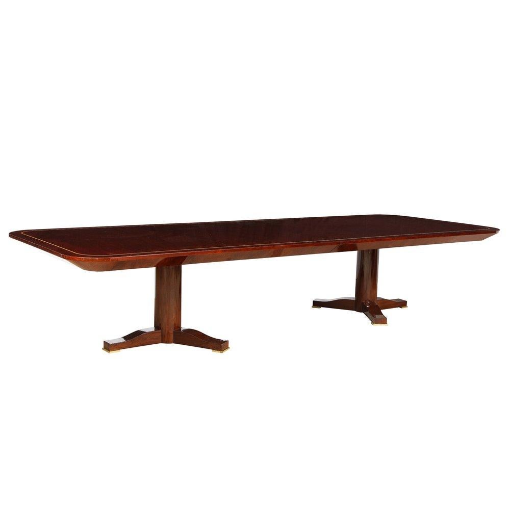 Rare monumental “Regency Extension Dining Table” with 2 matching leaves, top in book-matched Brazilian rosewood with satinwood inlay in high gloss finish with knife edge design, with 2 pedestal bases and solid brass feet by Karl Springer, American