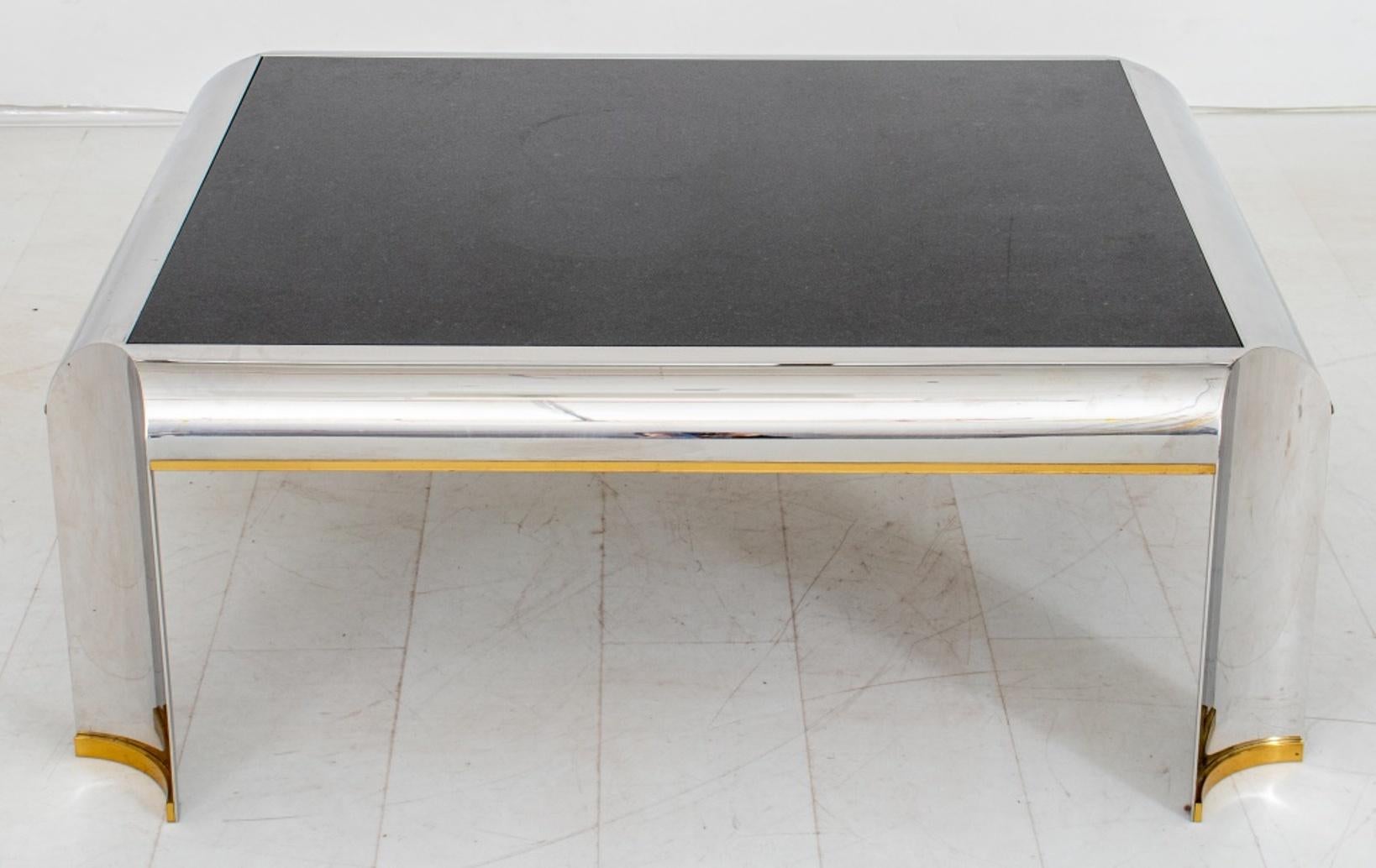 Table basse ou de cocktail de style Karl Springer (allemand/américain, 1931-1991) avec une structure en métal chromé et quatre pieds concaves, des pieds en laiton doré et un plateau en marbre noir.

Dimensions : 16