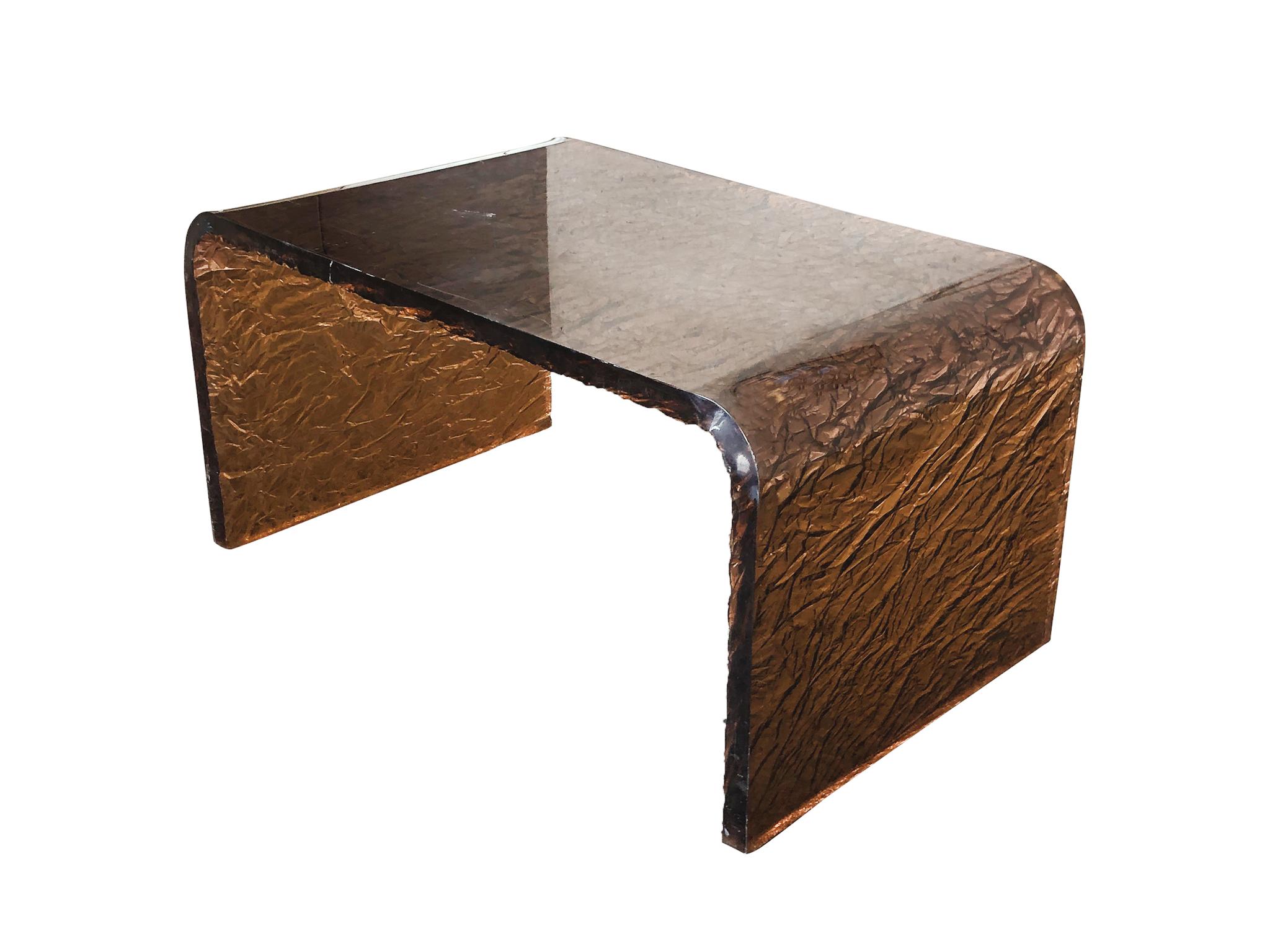 1970s-1980s Lucite side-table or small coffee table in the style of Karl Springer. We love this little table for its charm and beauty: its smooth waterfall structure, its translucent copper tone, and its textured underside that reminds us of