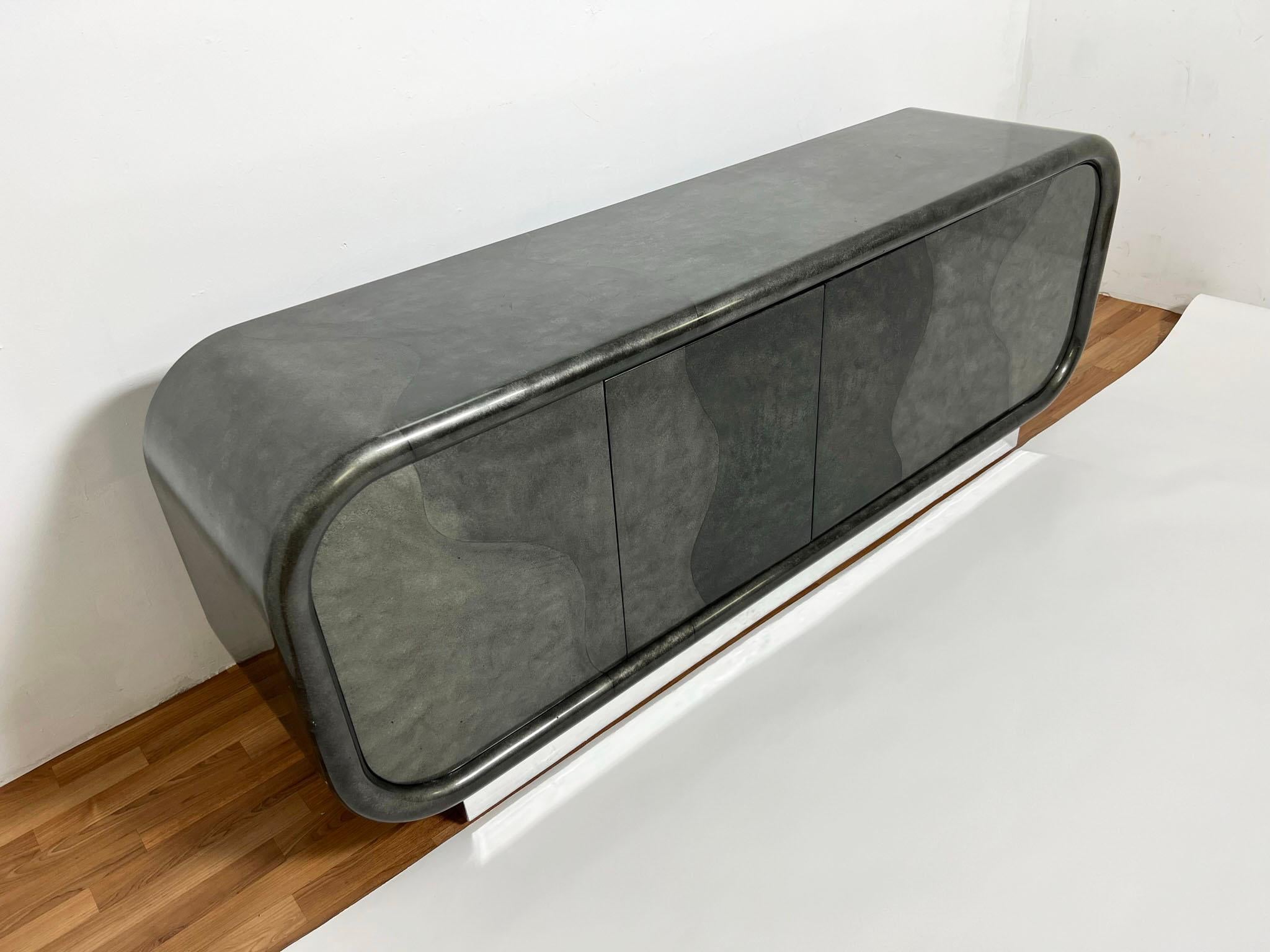 A post modern lacquered credenza in silvered black faux goatskin atop a chrome platform, ca. 1980s, in the style of Karl Springer.