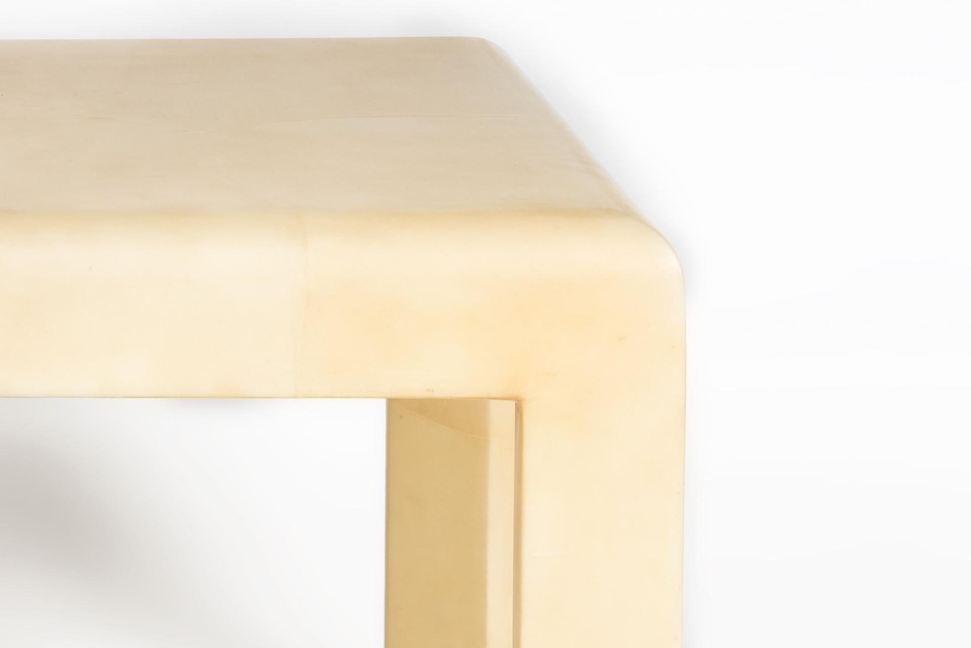 Cette table d'appoint moderne, dans le style de Karl Springer, a un look contemporain et unique grâce à sa matière en peau de chèvre blanc crème. Les angles sont arrondis et le plateau ainsi que les pieds sont fabriqués en peau de chèvre.
 