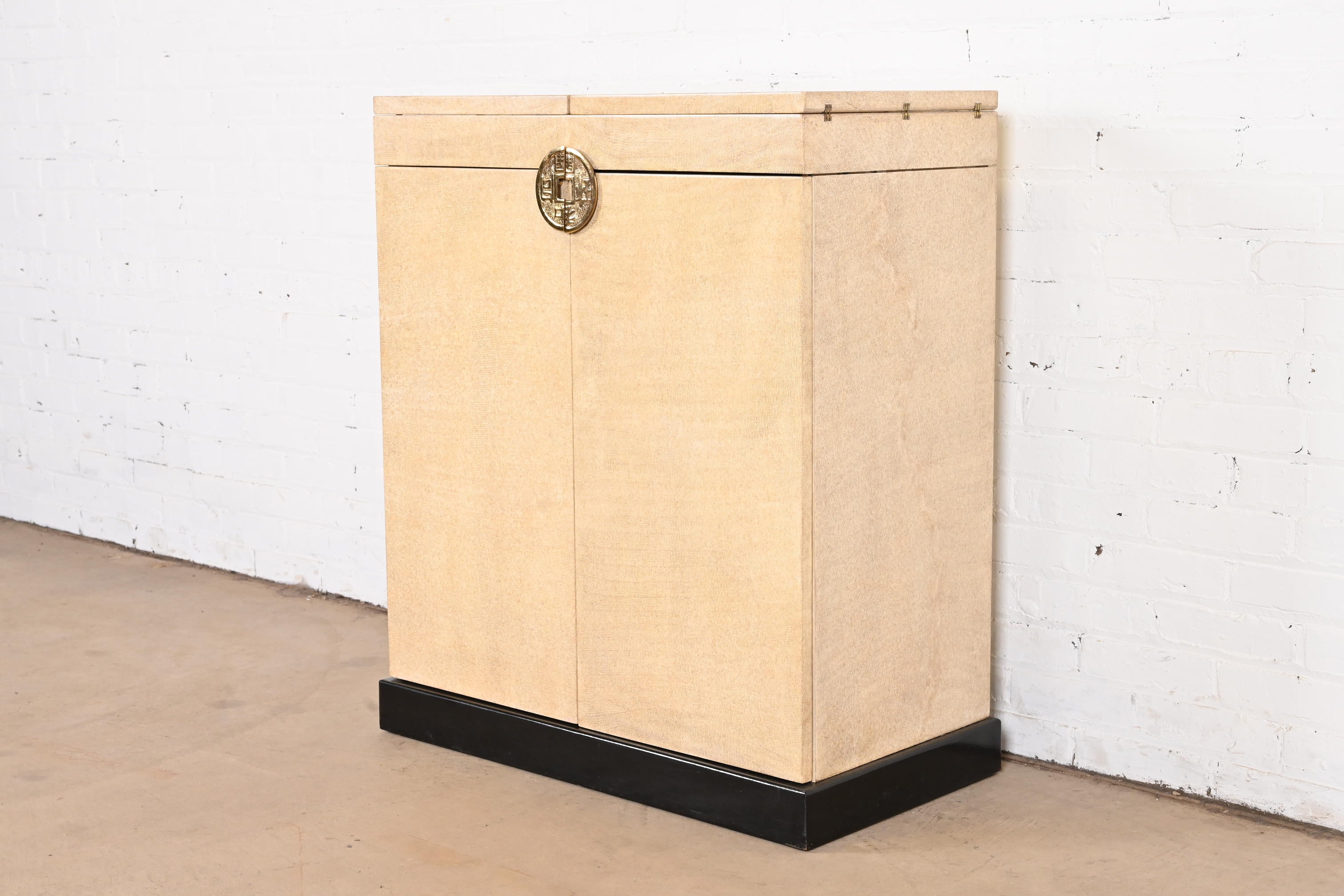 A gorgeous Hollywood Regency Chinoiserie faux snakeskin flip top server or bar cabinet

Procured from a multi-million dollar Palm Beach estate.

In the manner of Karl Springer

USA, circa 1970s

Faux snake skin, with Asian-inspired brass