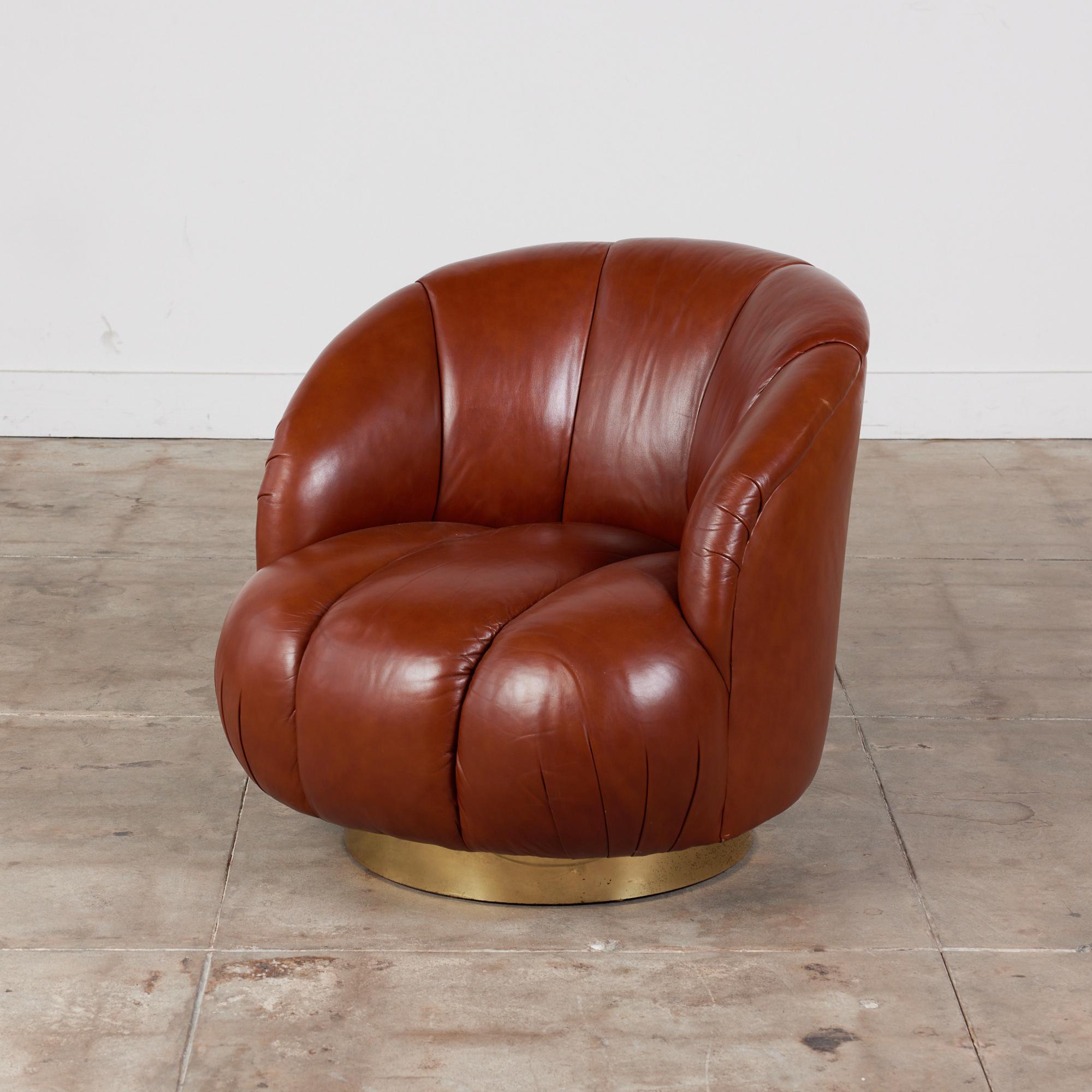 Karl Springer style swivel chair, c.1980s. The chair features soft curves throughout and upholstered in a rich tufted brown leather. The rounded seat back offers comfort and style. The chair rests on a simplistic brass round swivel base. 

Two