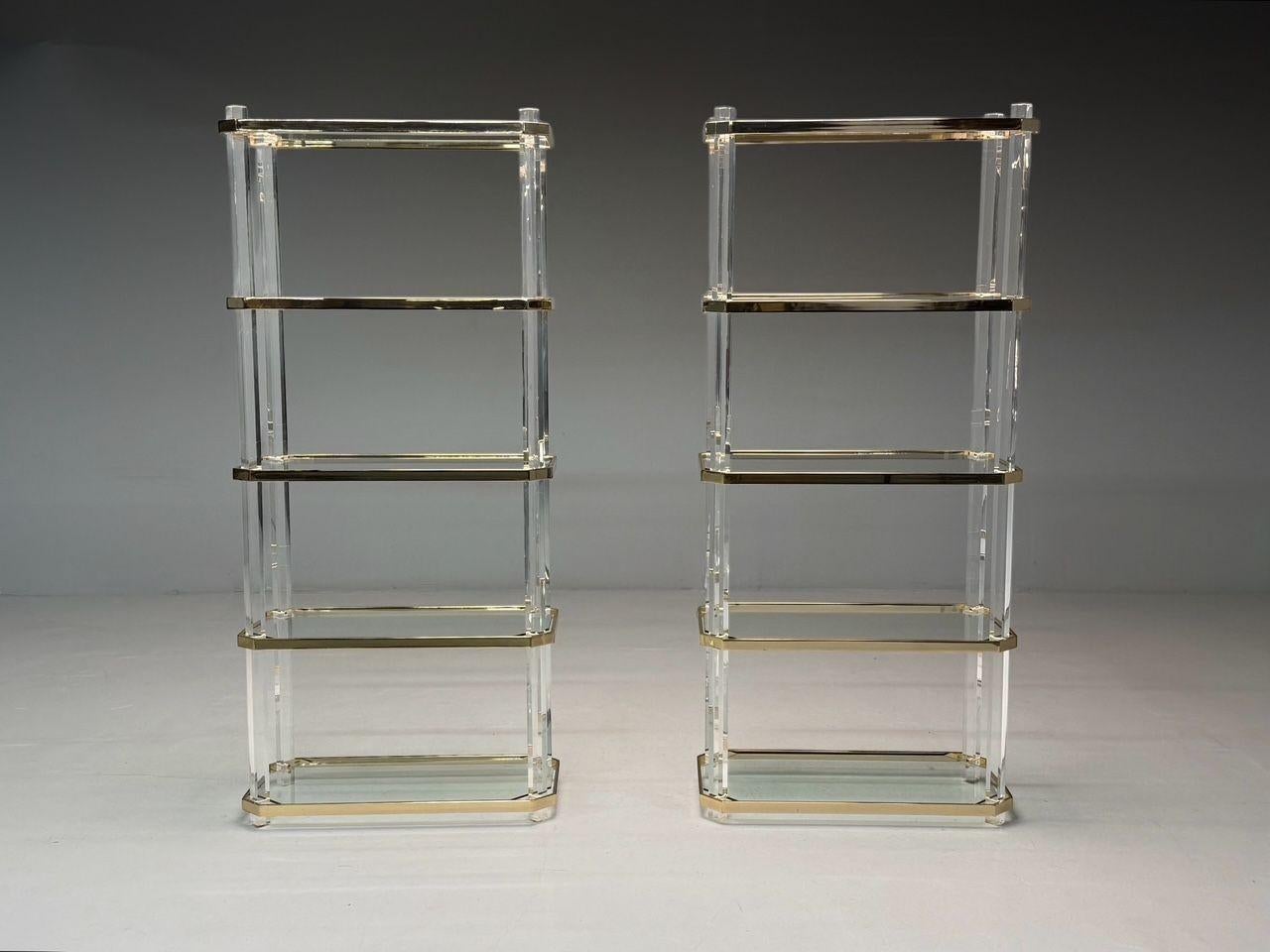 Karl Springer Style, Mid-Century Modern, Bookcases or Shelving Units, Lucite, Brass, USA, 1960s

A pair of lucite and brass etageres, reminiscent of Karl Springer’s design, featuring four Lucite legs supporting five glass shelves with patinated