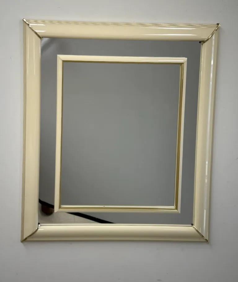 uno specchio da parete in stile Karl Springer, moderno e di metà secolo, caratterizzato da un'eleganza minimalista e da una raffinata lavorazione artigianale. La struttura è realizzata con una finitura beige laccata e liscia, che trasmette un senso