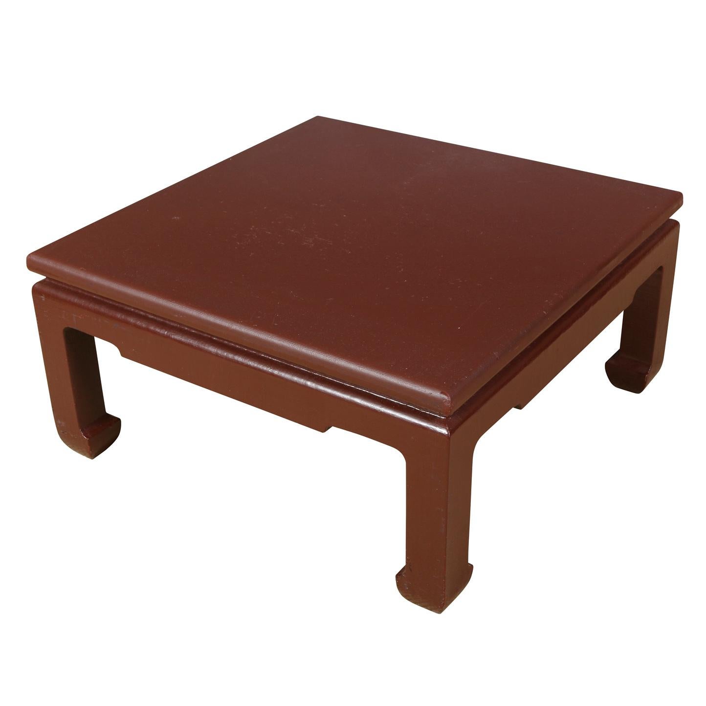 A Karl Springer style oxblood lacquered grasscloth cocktail table with Asian style feet.