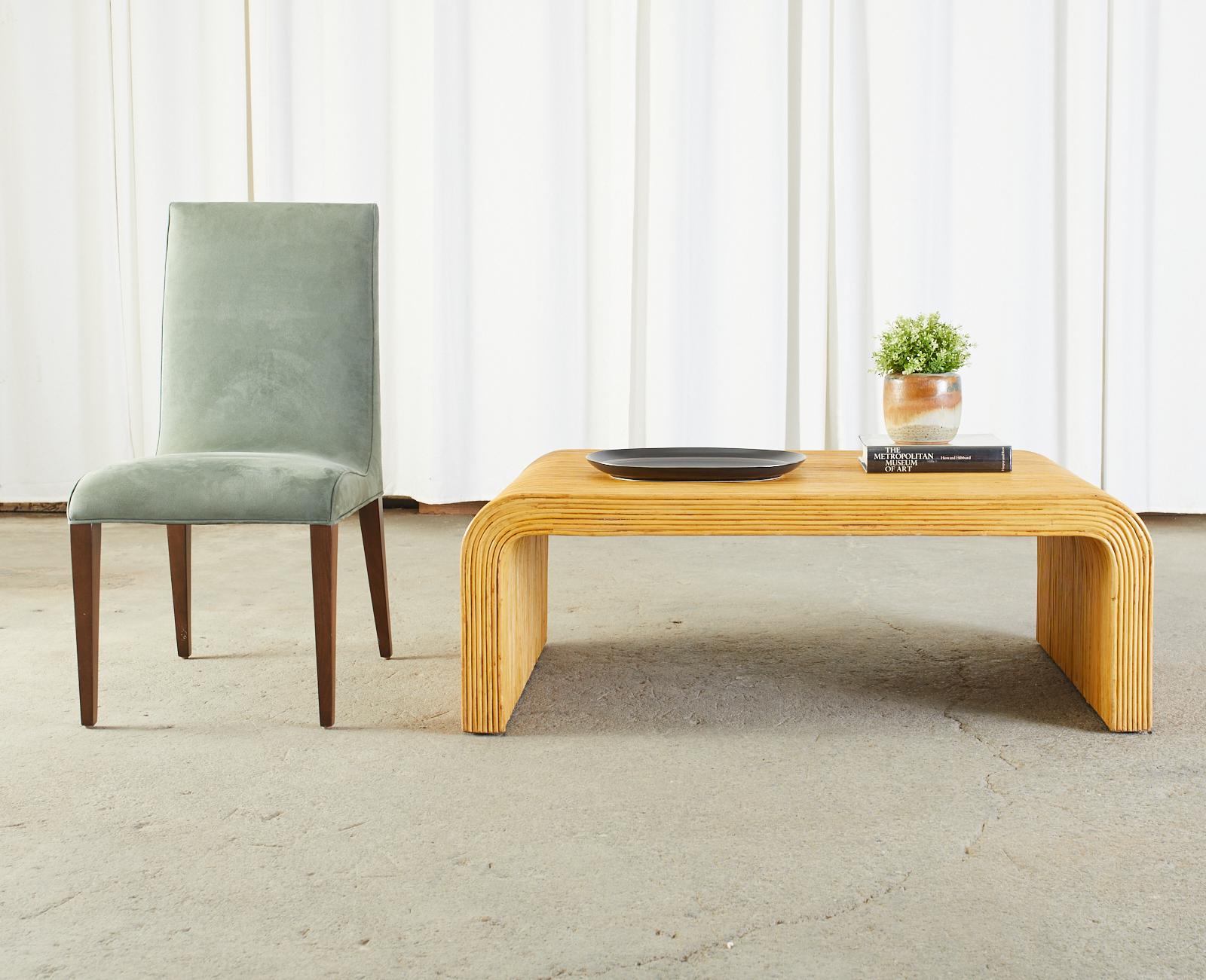 Mid-Century Modern waterfall coffee cocktail table featuring a pencil reed rattan finish. The table is unmarked however it is made in the organic modern style of Karl Springer and Jean-Michel Frank. Finished on all sides and inside the legs the