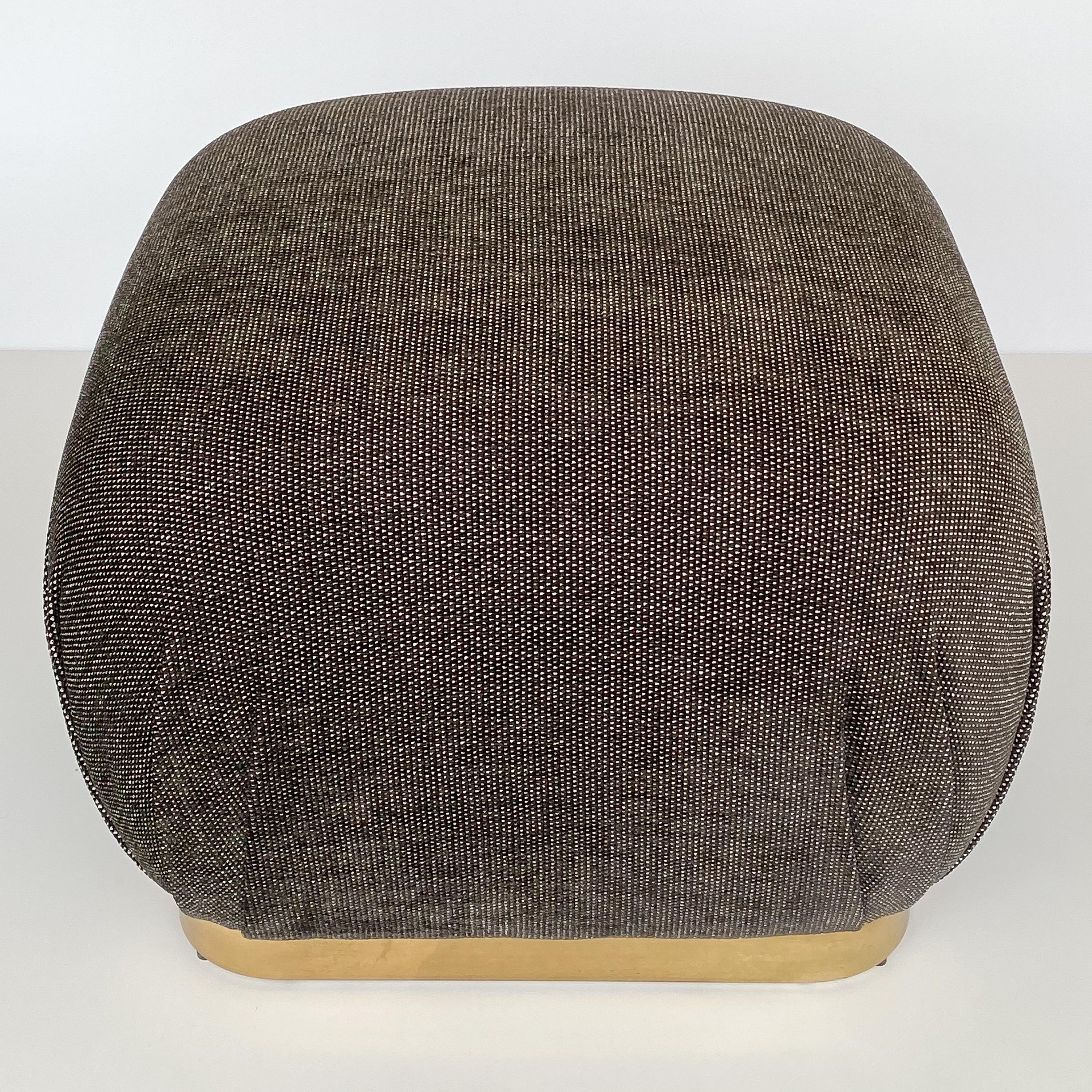 A Karl Springer style bronze tone soufflé pouf ottoman, circa 1970s. This ottoman has been newly upholstered in a viscose blend chenille fabric in a warm gunmetal gray and white dot. New foam throughout. 2