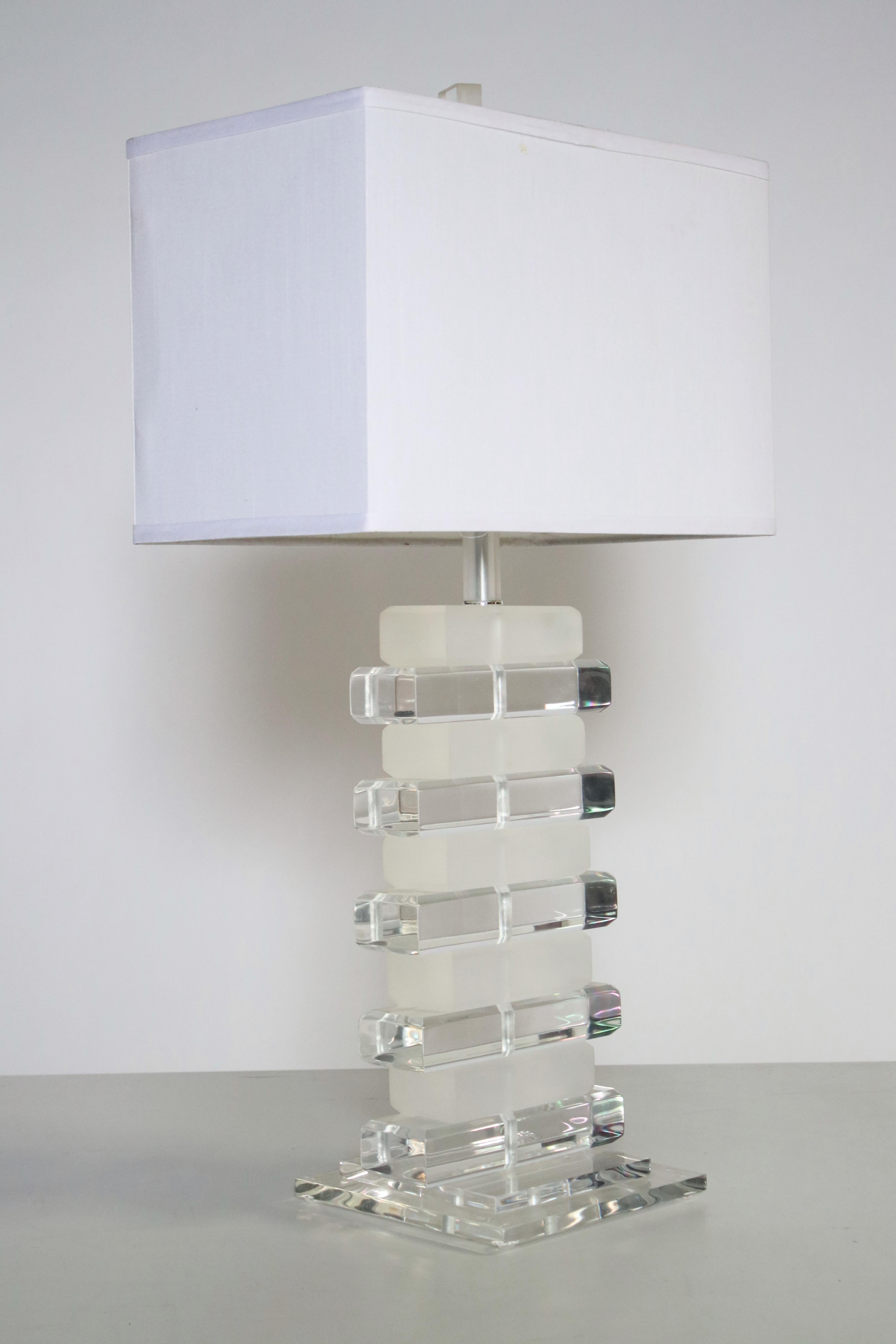 1970s table lamp in the style of Karl Springer with alternating stacks of frosted and clear Lucite. Wired and in excellent working condition. Lamp measures 22