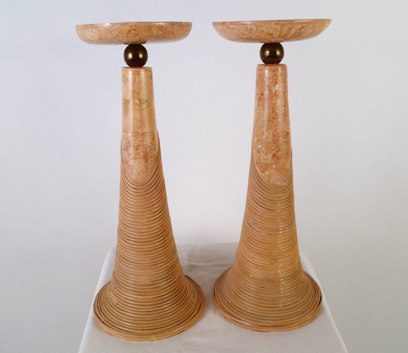 Modern and organic, this pair of tall tessellated marble candleholders are attributed to Karl Springer. They are in a 1980s pink with brass ball supports and an undulating cane design affixed. Each can hold a single candle. With a Made in