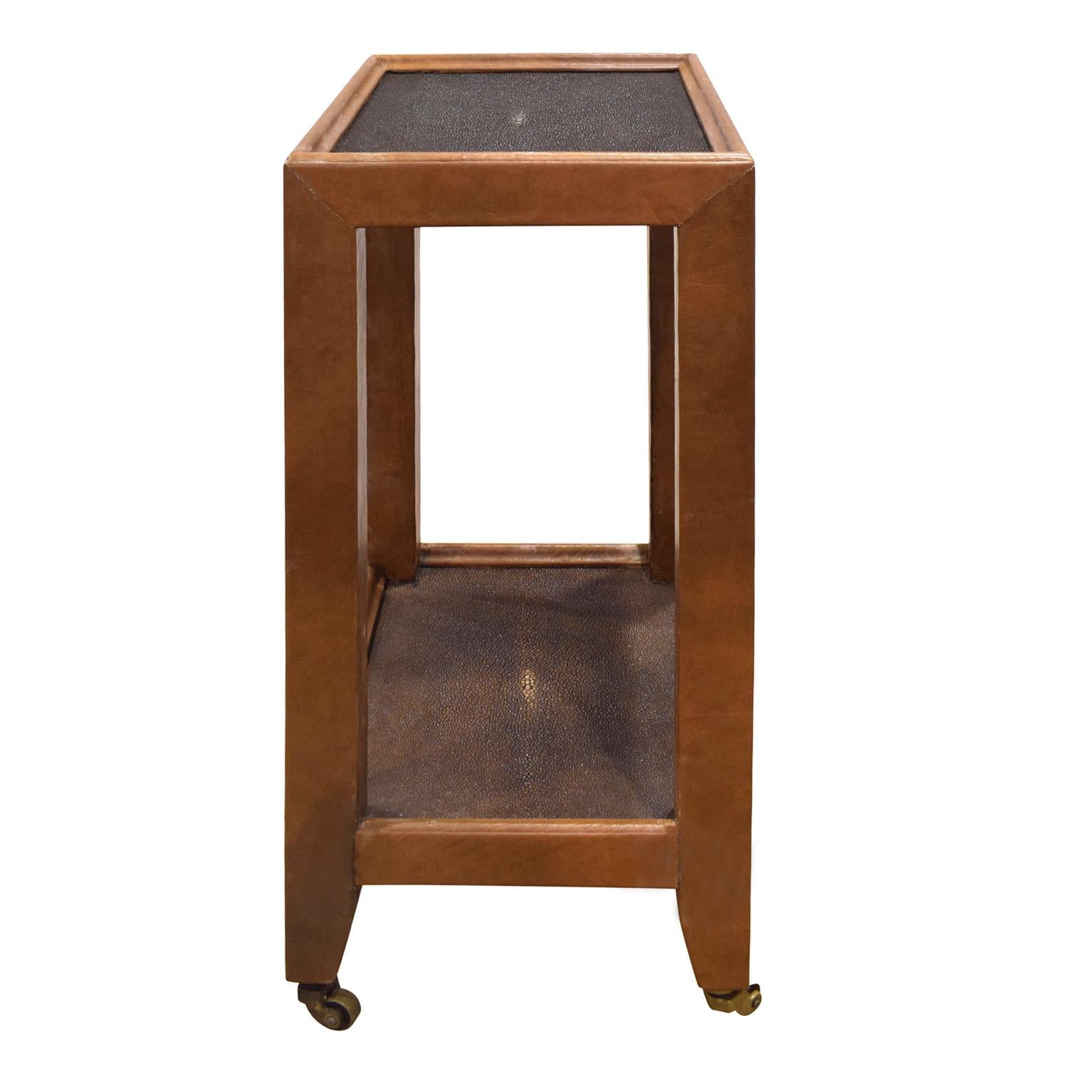 Exceptionnelle table d'appoint de style Table de Téléphone recouverte de cuir brun avec des plateaux en galuchat brun foncé sur roulettes en laiton par Karl Springer, américain des années 1980. Le fond est recouvert de daim assorti. L'artisanat