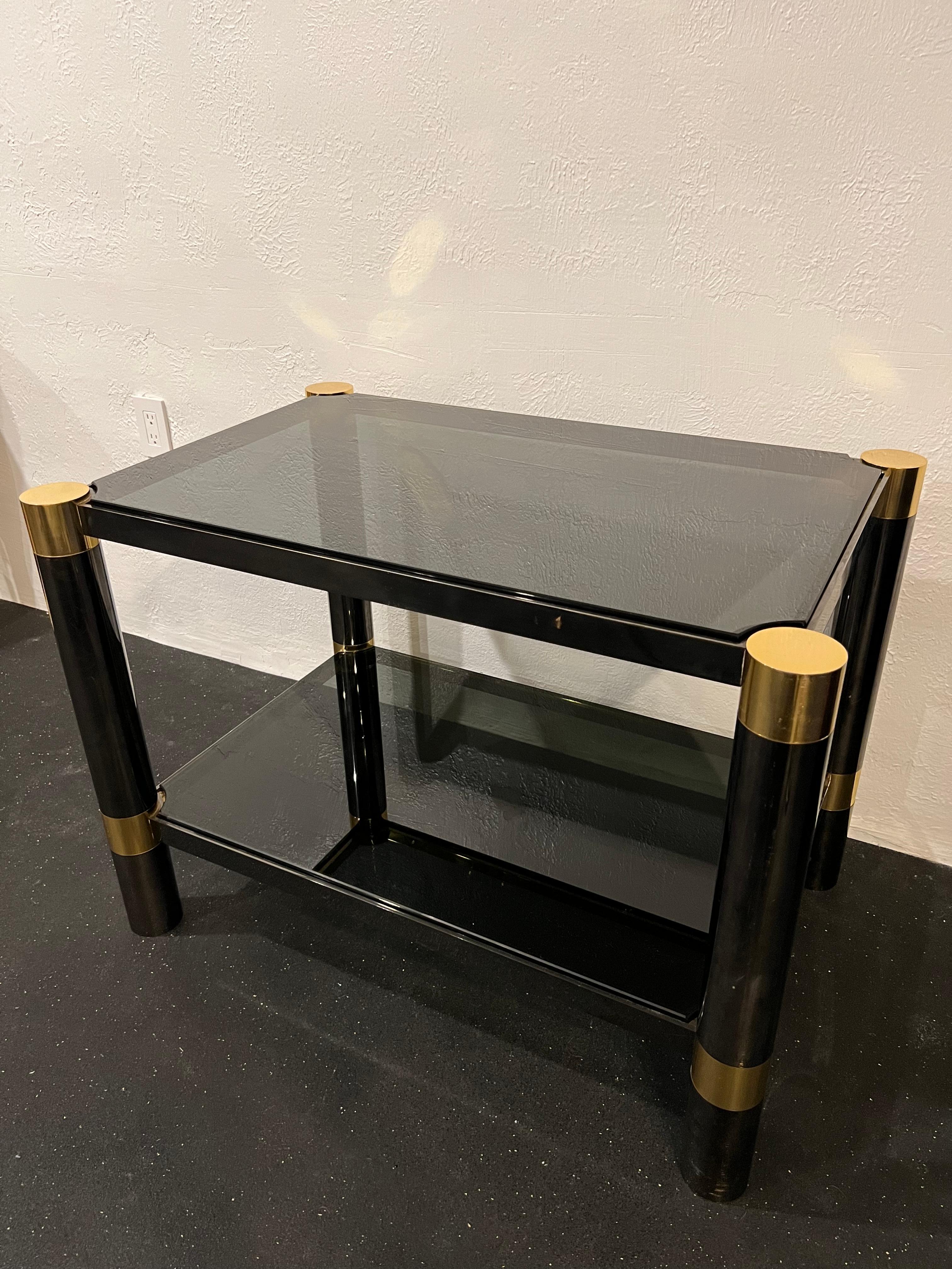 Karl Springer two-tiered gun metal and brass table, unsigned. Original smoked glass shows signs of wear/wear to gun metal finish (please refer to photos). 

Would work well in a variety of interiors such as modern, mid century modern, Hollywood