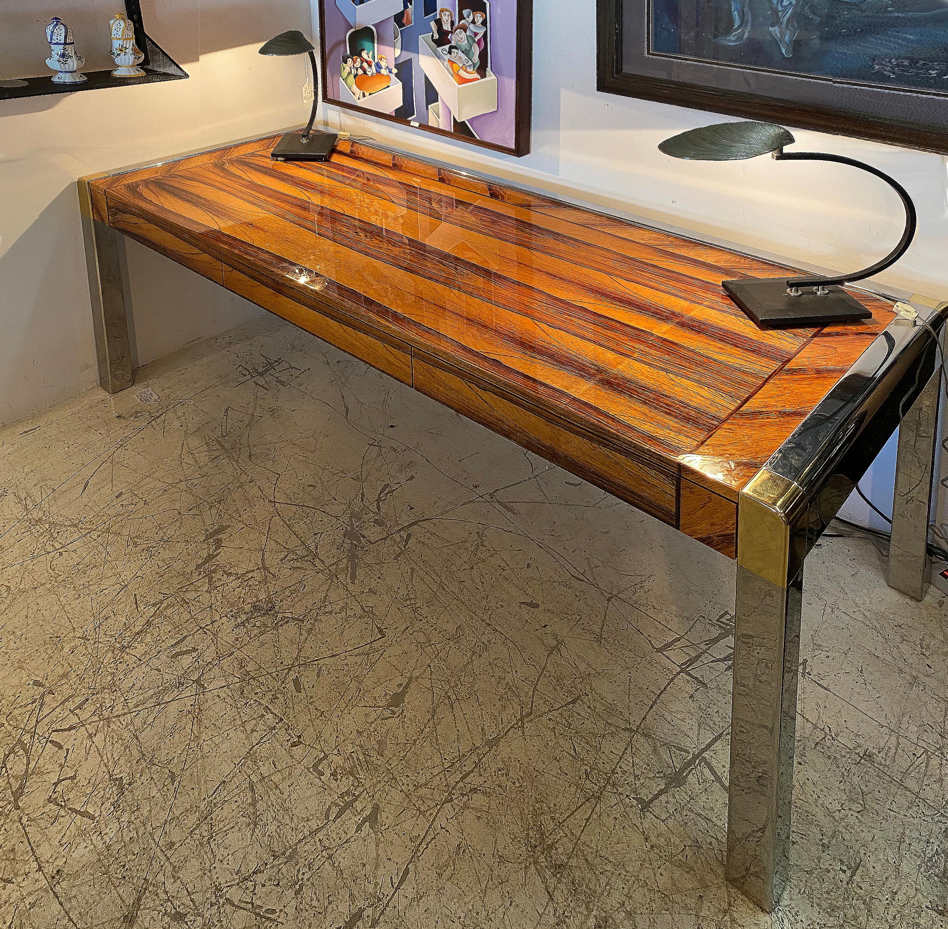 Karl Springer zebrawood writing desk with stainless steel and brass accents

Offered for sale is a highly polished Karl Springer exotic zebrawood writing desk with a stainless steel frame and brass corners. The desk offers storage across the front