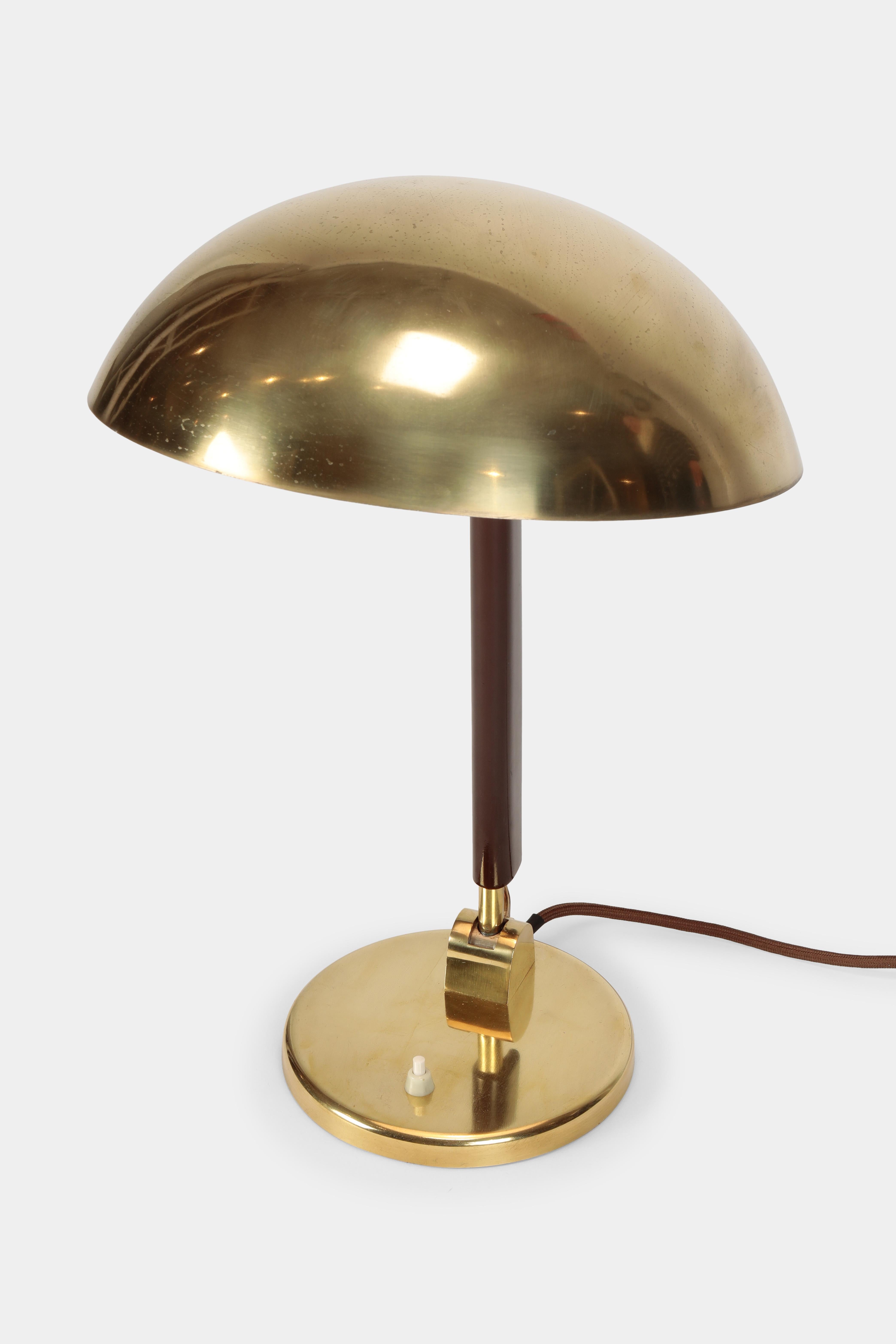 Karl Trabert table lamp manufactured in the 1930s by G. Schanzenbach, Germany. Brass lamp shade inside white lacquered on a solid brass base, brown lacquered wood in between.
 