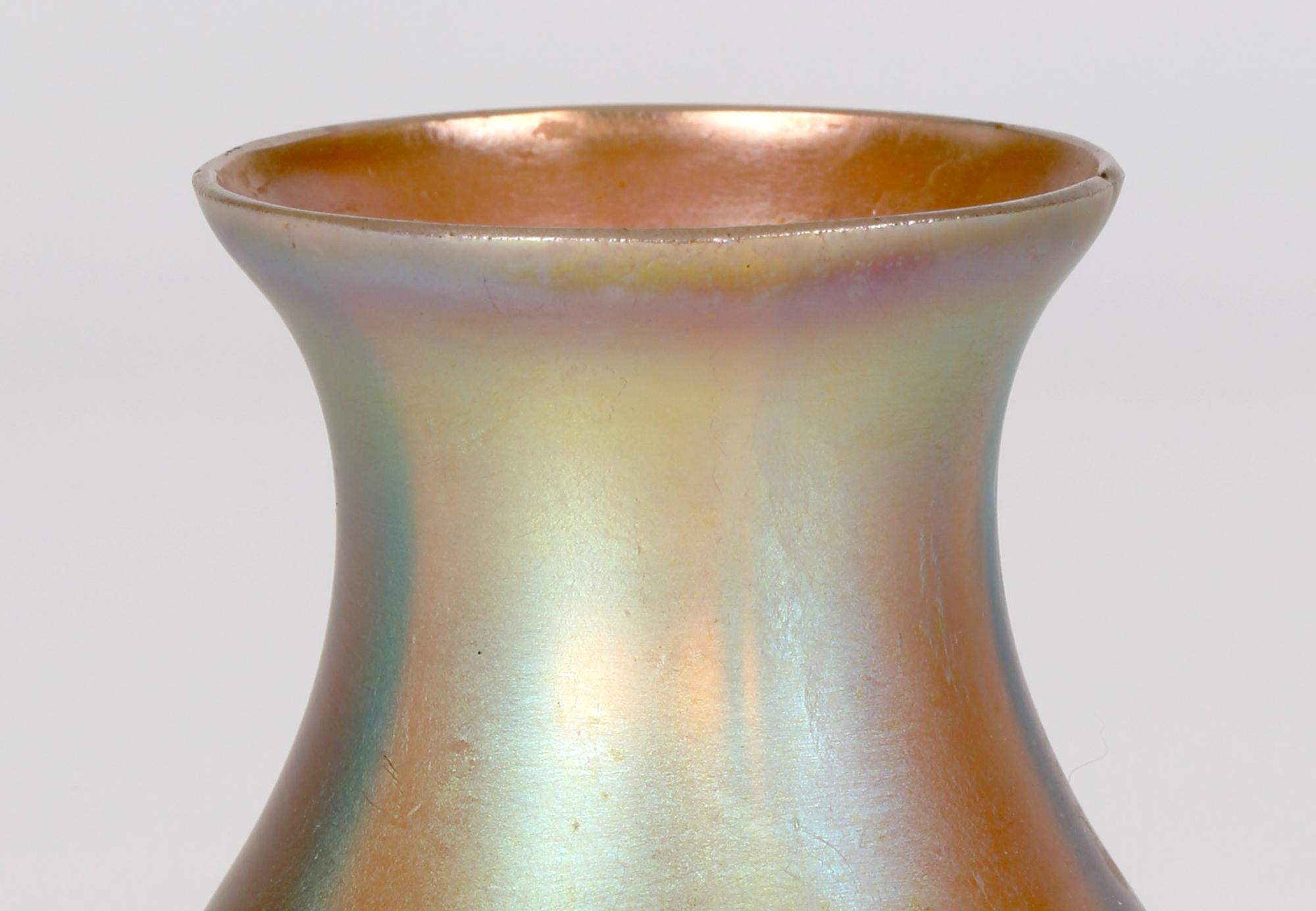 Finely made German Art Deco Myra Kristal miniature iridescent art glass vase by Karl Wiedmann for WMF (Würtemburgische Metallwaren Fabrik) and made between 1926 and 1936. This elegant amber glass vase has a narrow round foot with a bulbous tear drop