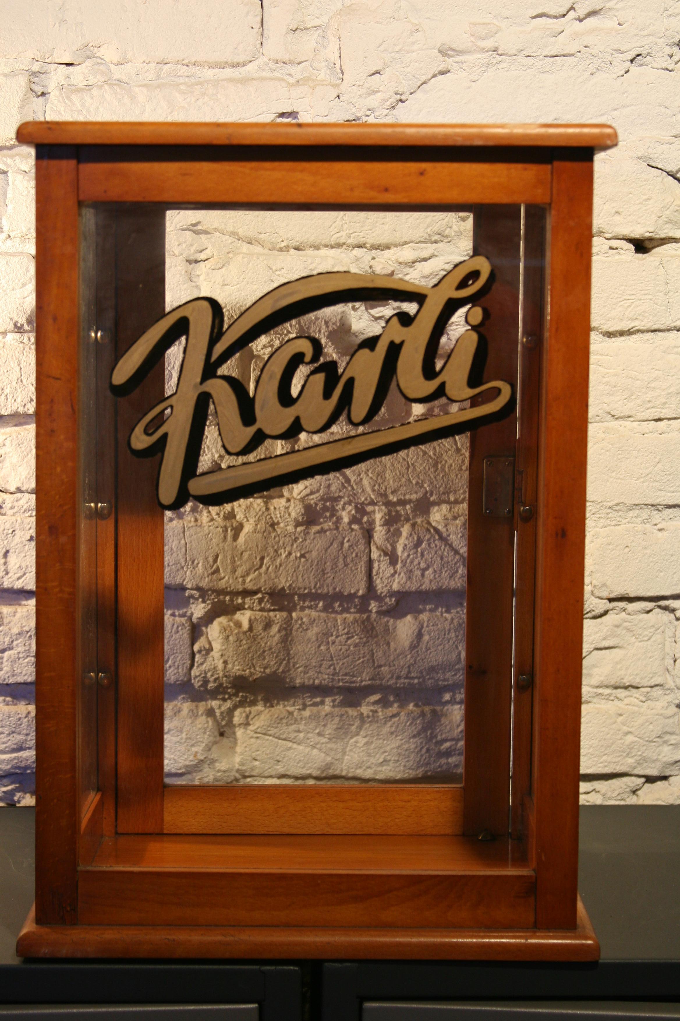 Original German glass cage.
Construction:
The frame is made of solid wood, the door opens at the rear, inside there are three glass shelves mounted on brass handles. On the windshield, original Karli Company advertisement painted in gold and