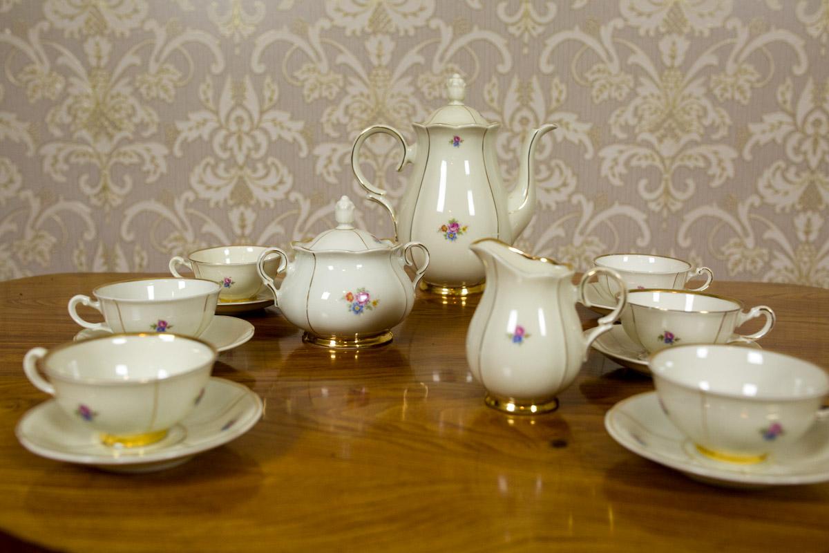 Smooth porcelain in a shade of ecru with gildings, ornamented with a subtle floral motif.

The service includes:
6 cups, height: 5 cm;
6 saucers, diameter: 12.5 cm;
a sugar bowl, height: 12 cm;
a milk jug, height 10 cm;
a jug, height: cm 22