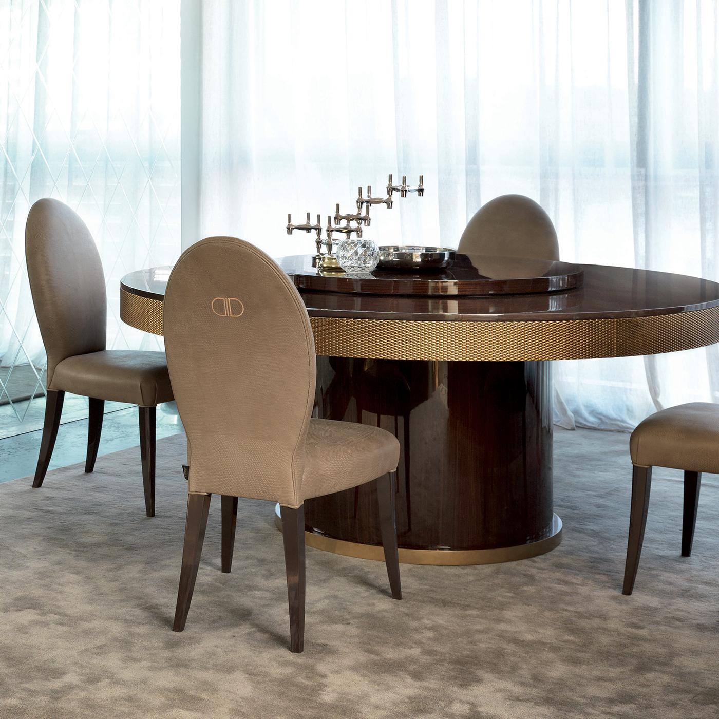This majestic, sculptural dining table will bring an elegant and distinctive character both in a Classic and contemporary decor. It features a plywood top with dark walnut veneer and brushed gloss finish, with a Lazy Susan element at its center and