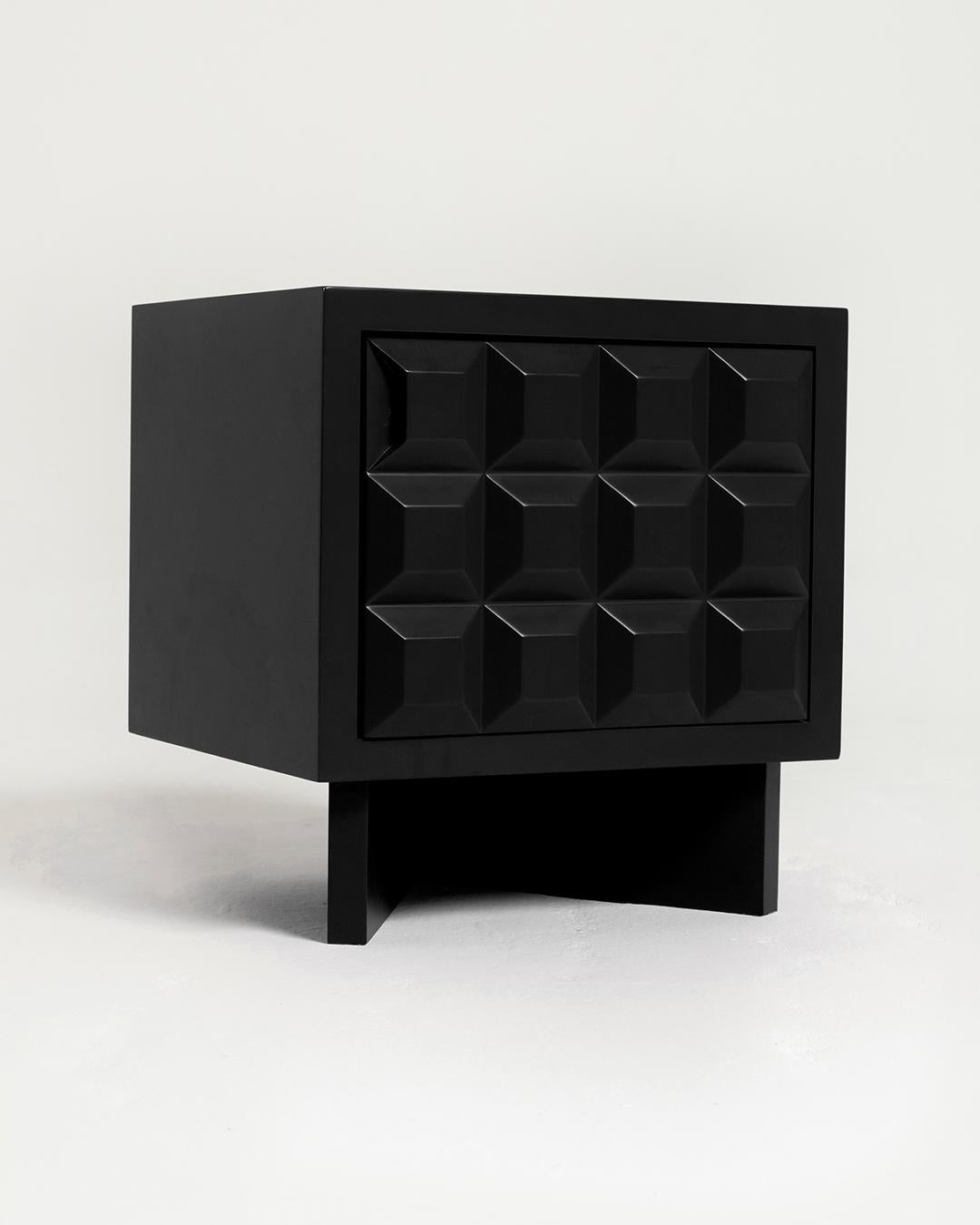 Inspired by Brutalism, an aesthetic movement and architectural style known for its sculptural, angular forms, the Karo nightstand’s front panel consists of dynamic carved diamond-shaped elements. The door, which swings open, reveals a shelf for