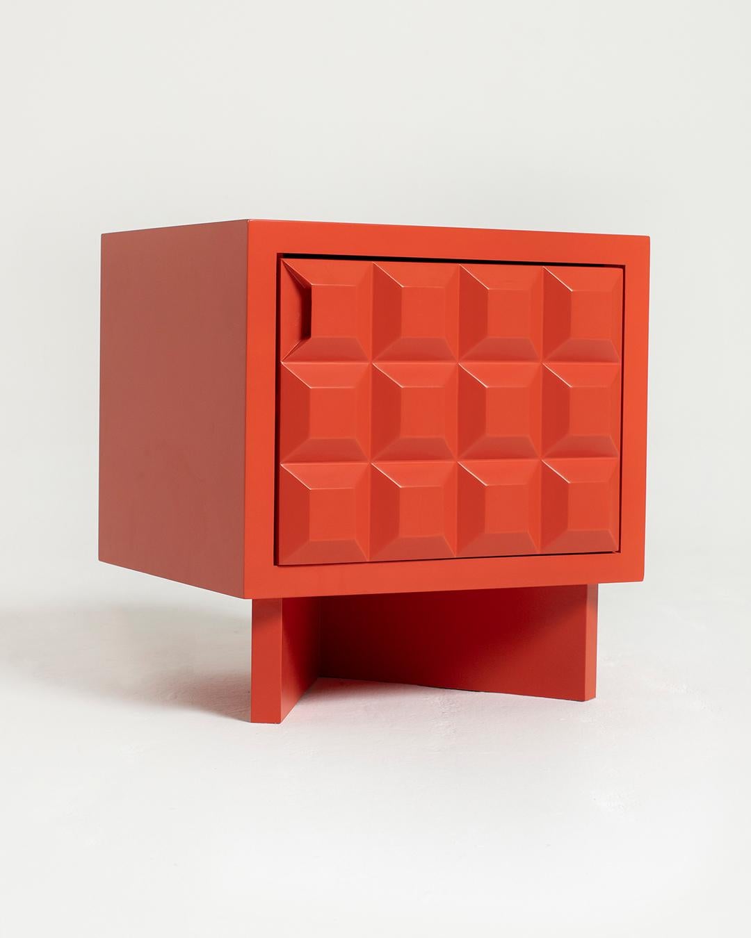 Inspired by Brutalism, an aesthetic movement and architectural style known for its sculptural, angular forms, the Karo nightstand’s front panel consists of dynamic carved diamond-shaped elements. The door, which swings open, reveals a shelf for