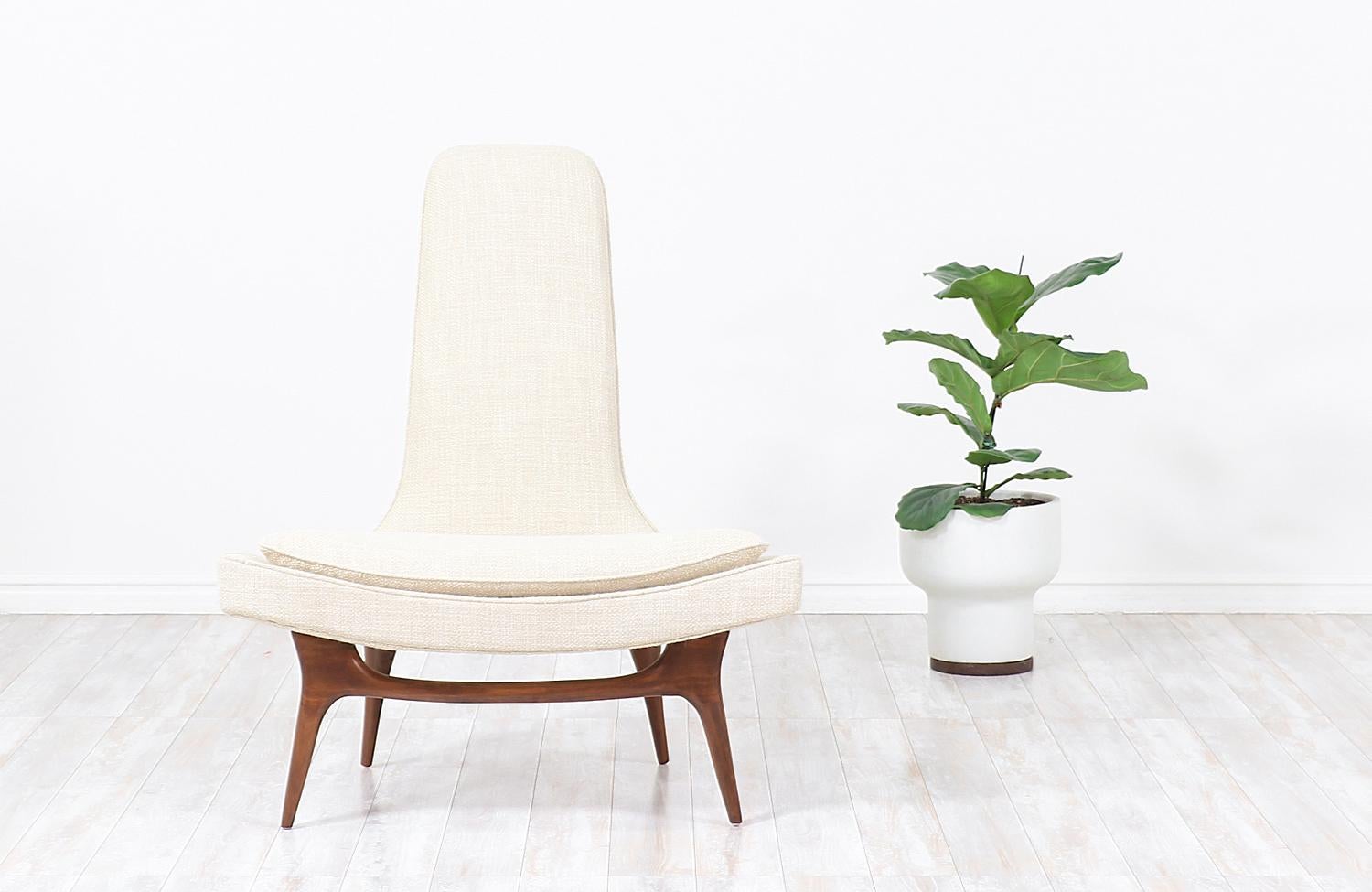 Stunning Mid-Century Modern high-back chair manufactured by Karpen of California for their iconic “Chair-Foam” line designed in the United States, circa 1960s. This luxury contoured lounge chair features a sturdy walnut wood base holding the molded