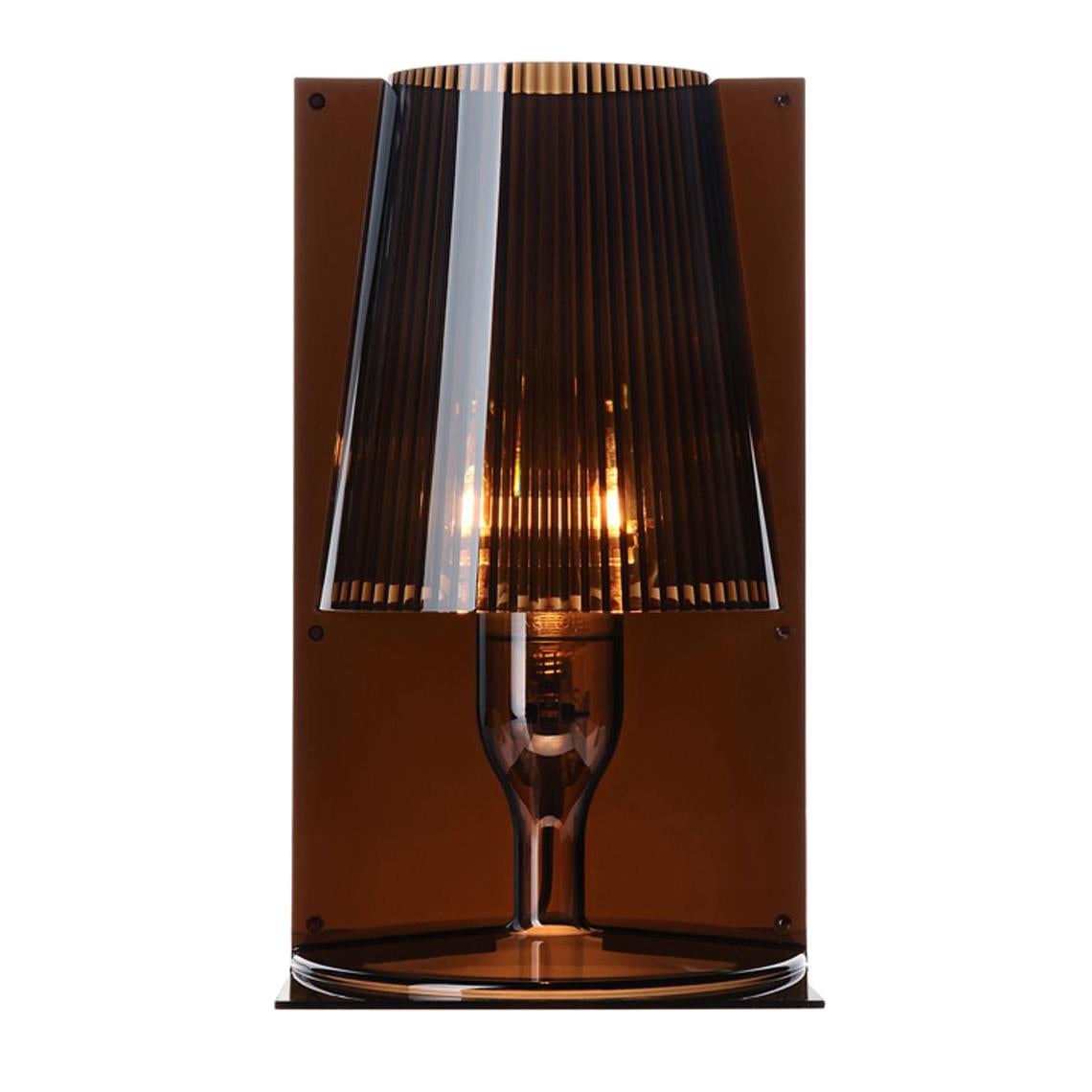 El icono clásico de la lámpara de mesilla de noche es revisitado por la tecnología de Kartell para convertirse en un producto industrial en una variedad de tonos de color. La forma de Toma es el resultado de la unión de dos partes especulares: dos