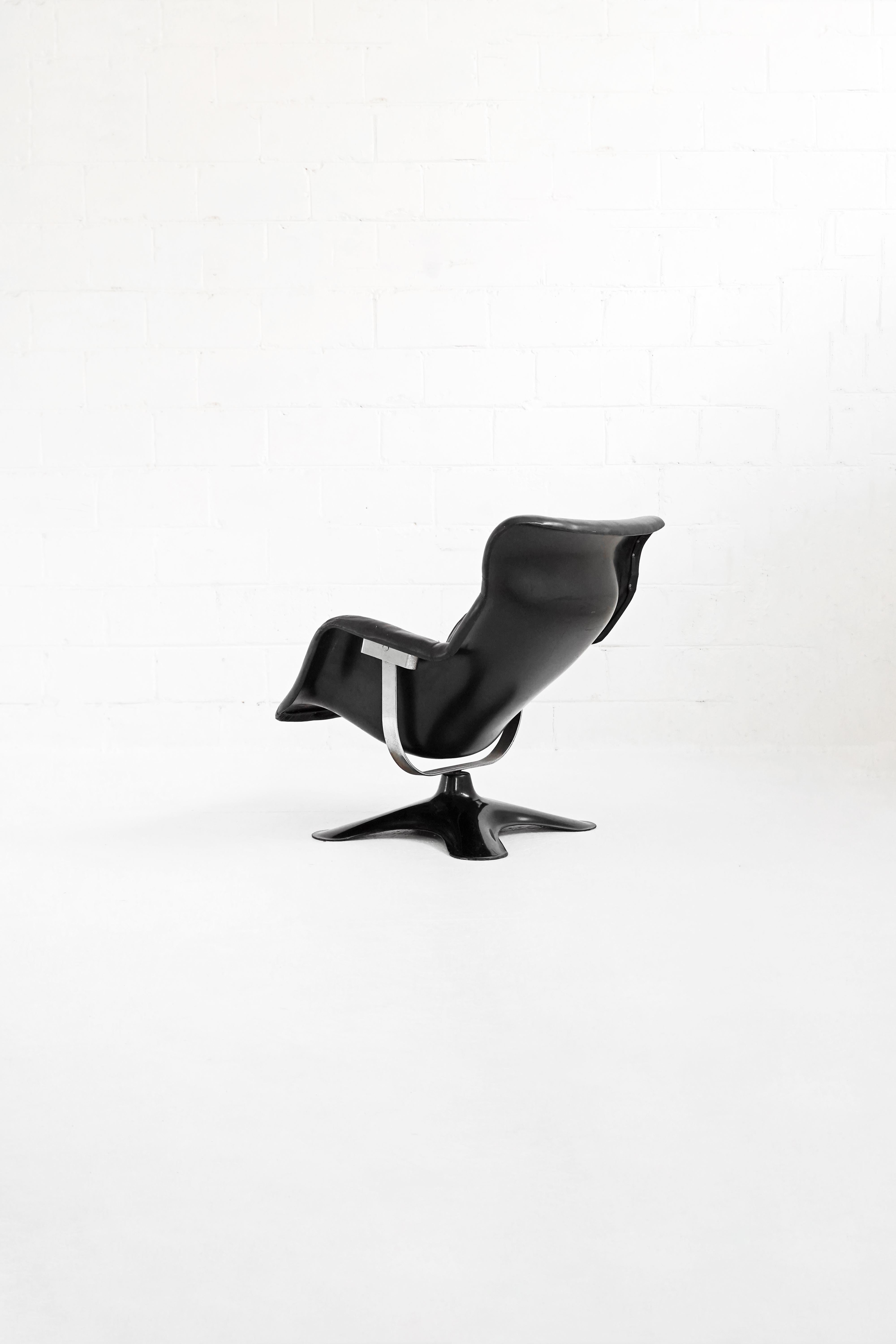 Very unique and comfortable lounge chair by Yrjo Kukkapuro for Haimi. 1960s-1970s production. A tilting molded plastic shell atop a chromed steel suspension frame and swivel base. Covered in original black leather showing signs of wear, does not