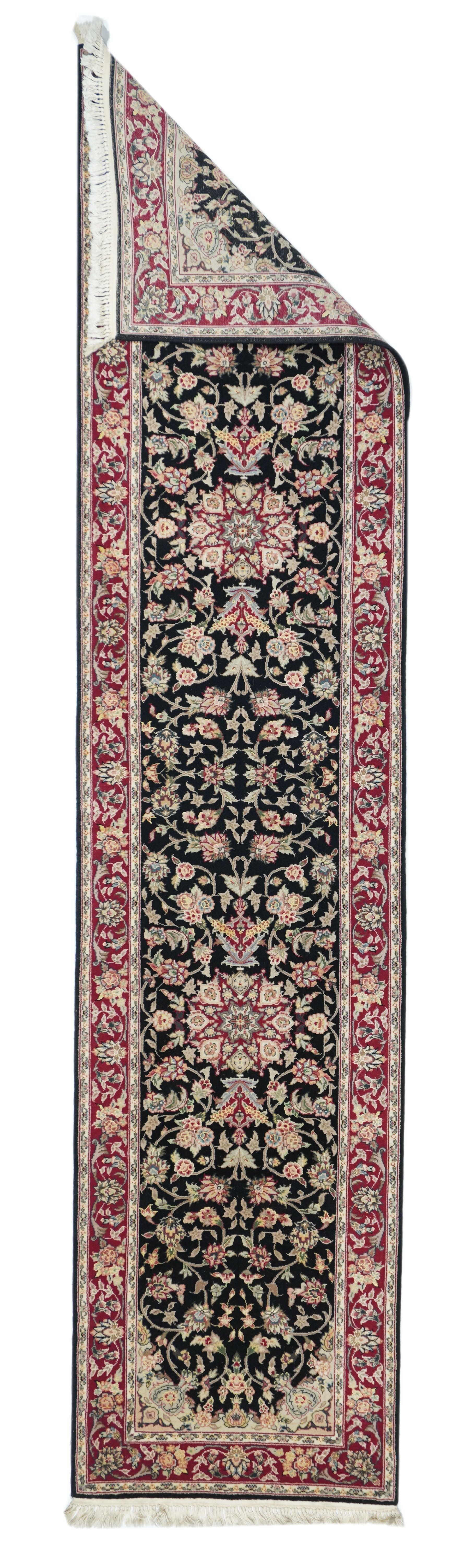 Kashan Runner 2'3'' x 10'0''. Gli angoli di paglia con vasi che si proiettano verso l'interno danno forma al campo quasi nero con i due medaglioni rossi interni a forma di stella a otto punte. Il fitto e vigoroso vigneto a volute arabescate è