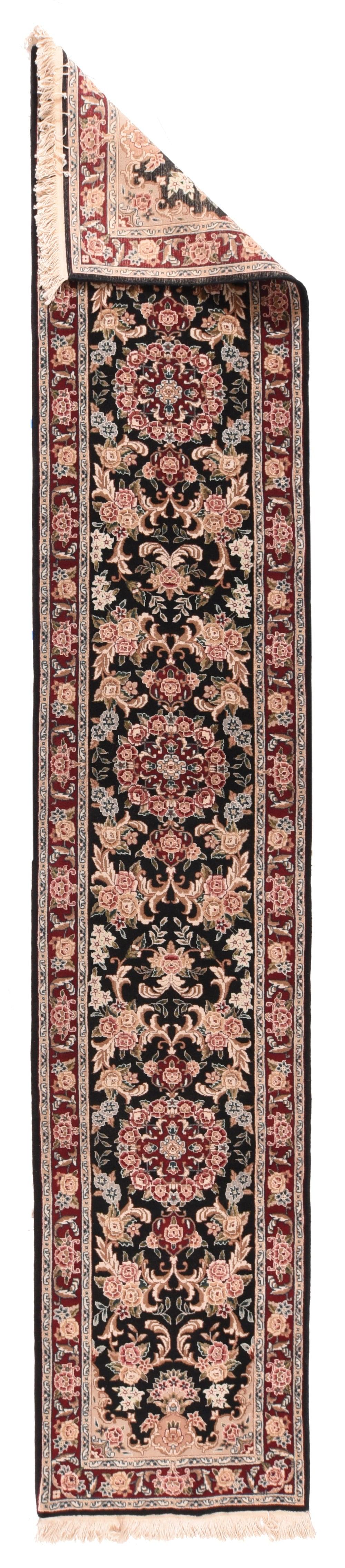 Kashan Läufer 2'3'' x 12'0''. Das fast schwarze Feld zeigt ein üppiges Muster aus drei rosenumkränzten runden Medaillons inmitten von einzelnen und dreifachen Rosengruppen und dynamischen Akanthusgabelblättern. Sehr dunkle weinrote Umrandung aus