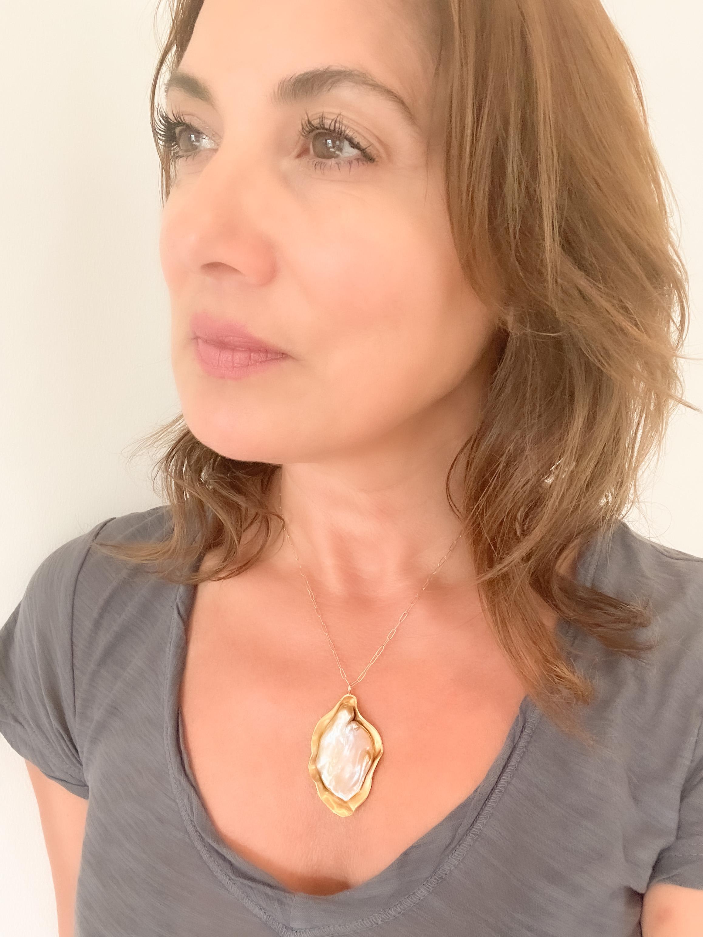 Il ciondolo Kashi Pearl in oro 22k è incastonato in un letto d'oro 22k. Scolpito e modellato a mano con una bellissima finitura opaca. Completa di una catenina fermacarte in oro 18k lunga 16