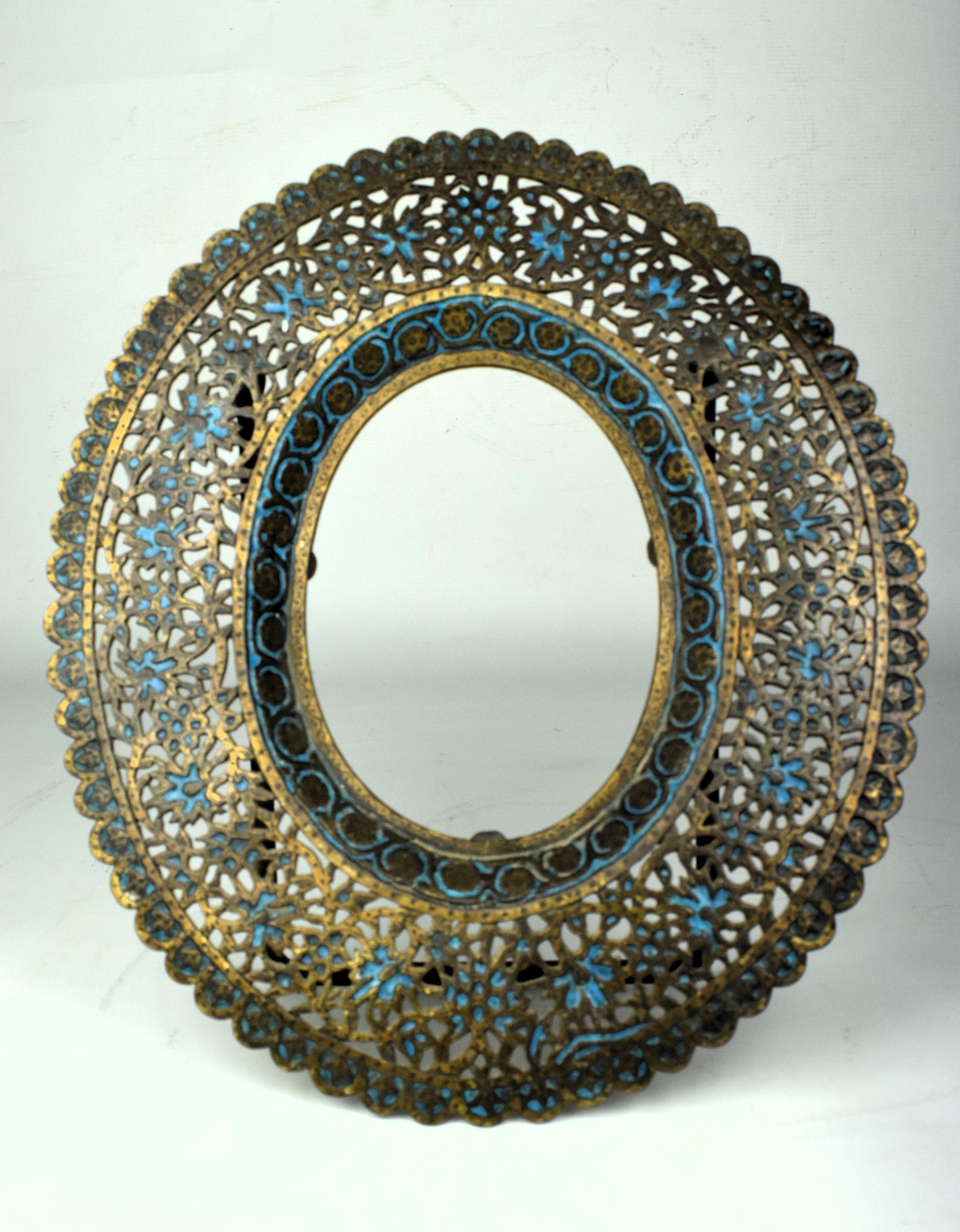 Crafted in the early 19th century, this Kashmiri brass cutwork enameled frame is a stunning example of the region's artistic prowess. The frame is made from high-quality brass, providing a durable and lustrous foundation for the intricate detailing