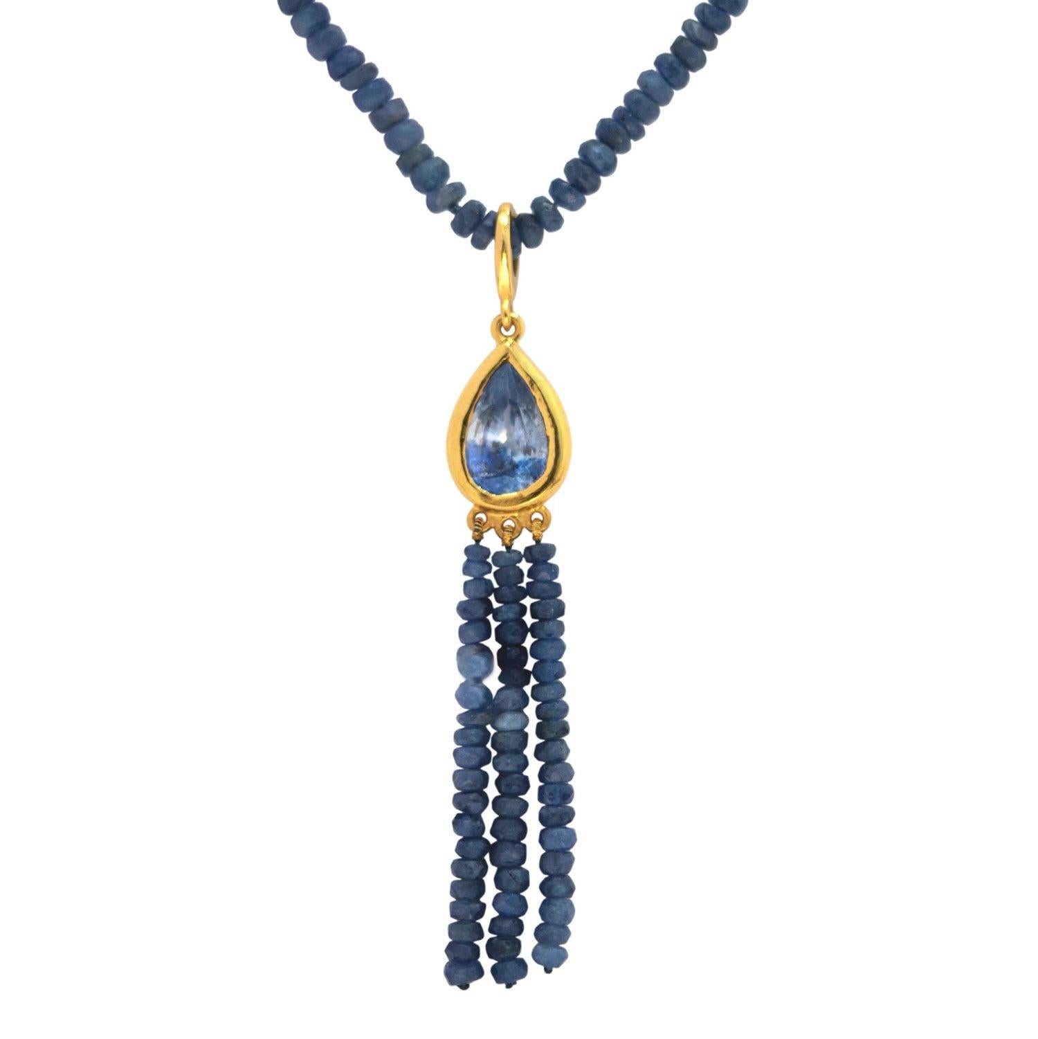 Tear Drop Sapphire Pendant featuring a Kashmir Blue Sapphire with spectacular luminous blue banding set in a Gold bezel suspending Sapphire tassels. This stunning pendant is styled on a necklace of fiery natural Sapphire beads.

- Kashmir Blue Tear