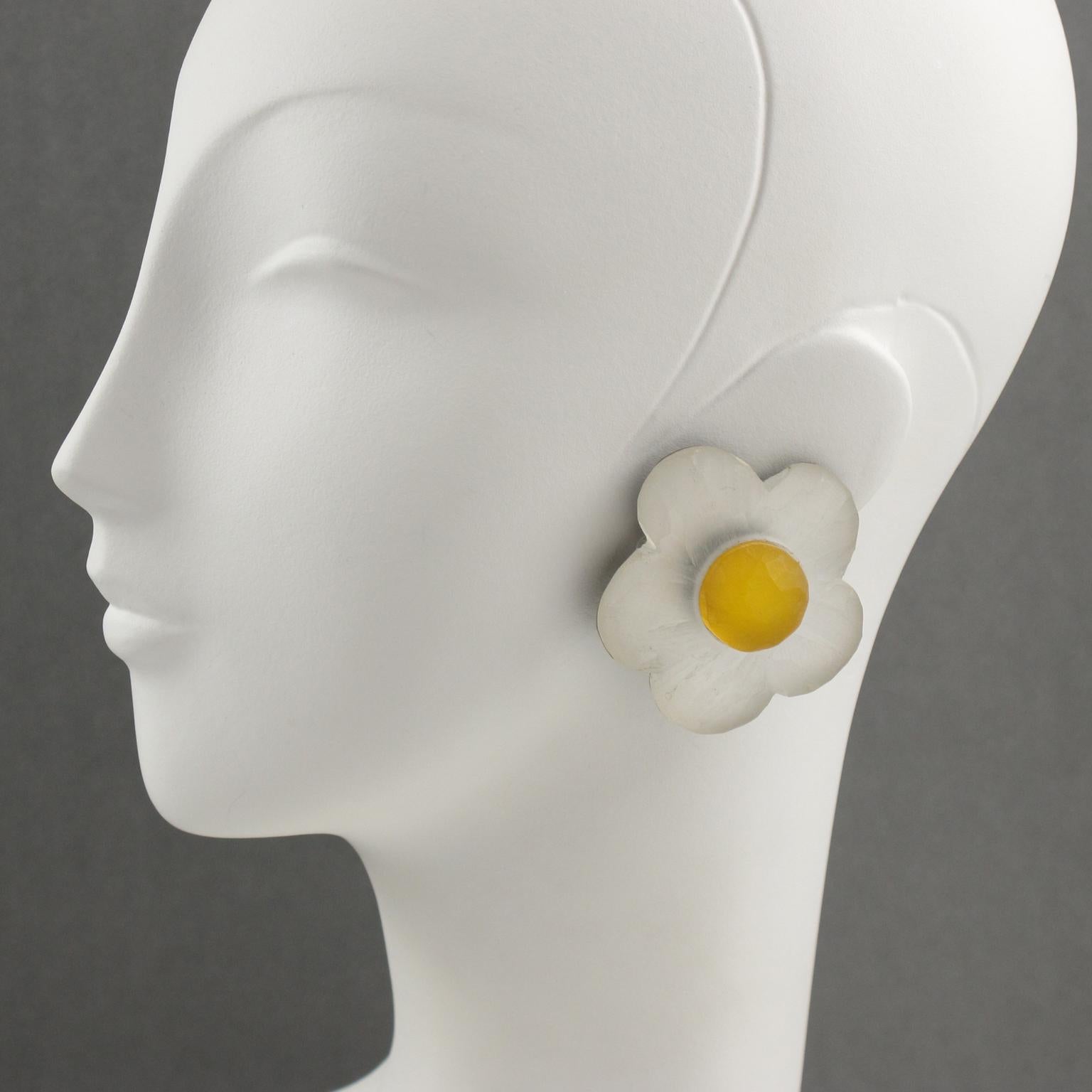 Gorgeous oversized frosted lucite clip-on earrings designed by Harriet Bauknight for Kaso. Dimensional shape all carved and textured featuring a daisy flower in frosted white and yellow colors. Signed at the back with the Kaso brand sticker