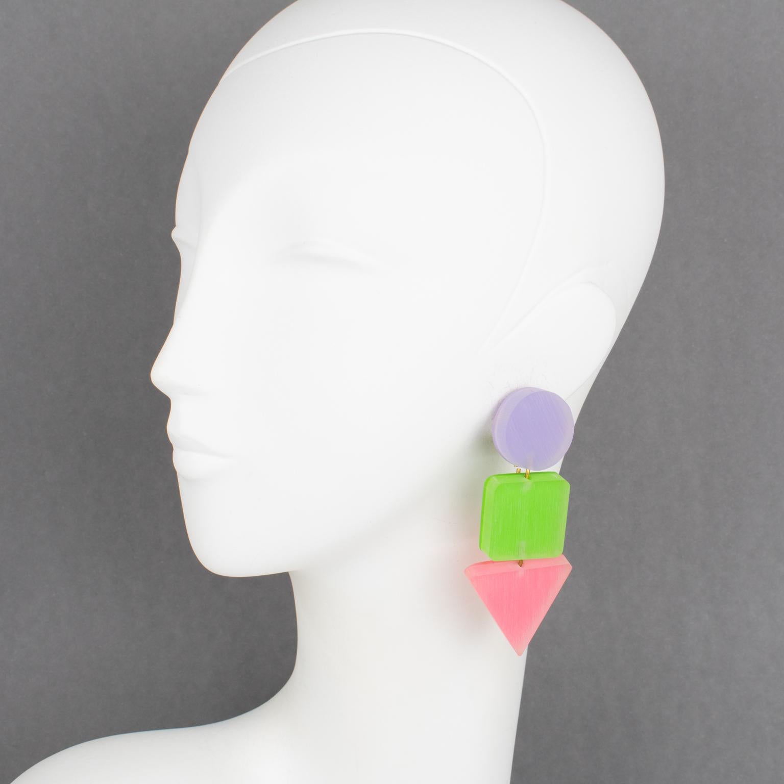 Harriet Bauknight for Kaso designed these rare, stunning, lucite clip-on earrings. They feature a geometric dangling design using frosted textured lucite in pastel purple, green, and pink. The original Kaso brand paper sticker is still on the back.