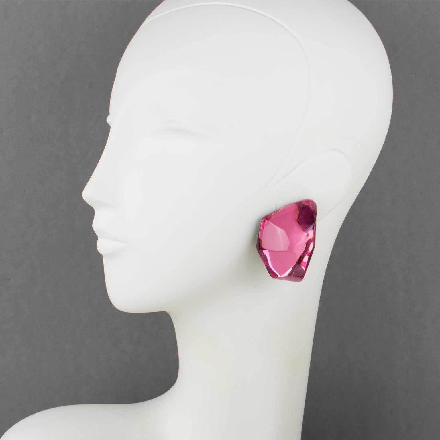 Harriet Bauknight designed these stunning Lucite clip-on earrings for Kaso. The pieces feature a dimensional giant ice cube with a hot pink mirror-textured pattern and beveling edges. 
The Kaso paper sticker was removed, but the gray background and