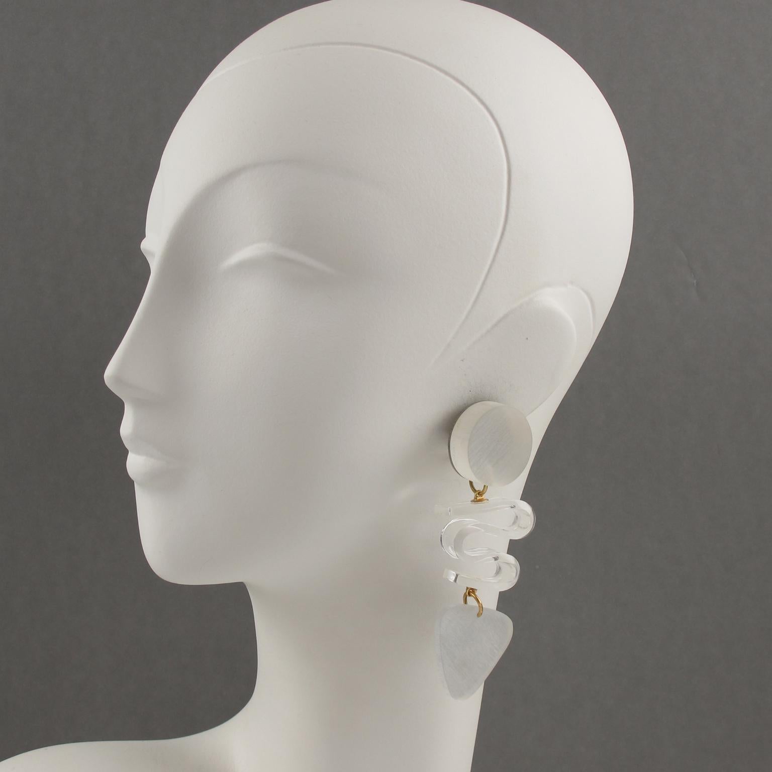 Stunning oversized Lucite clip-on earrings designed by Harriet Bauknight for Kaso. Huge chandelier dangling shape featuring a dimensional geometric design in frosted white color compliment with twisted transparent Lucite element. The earrings are