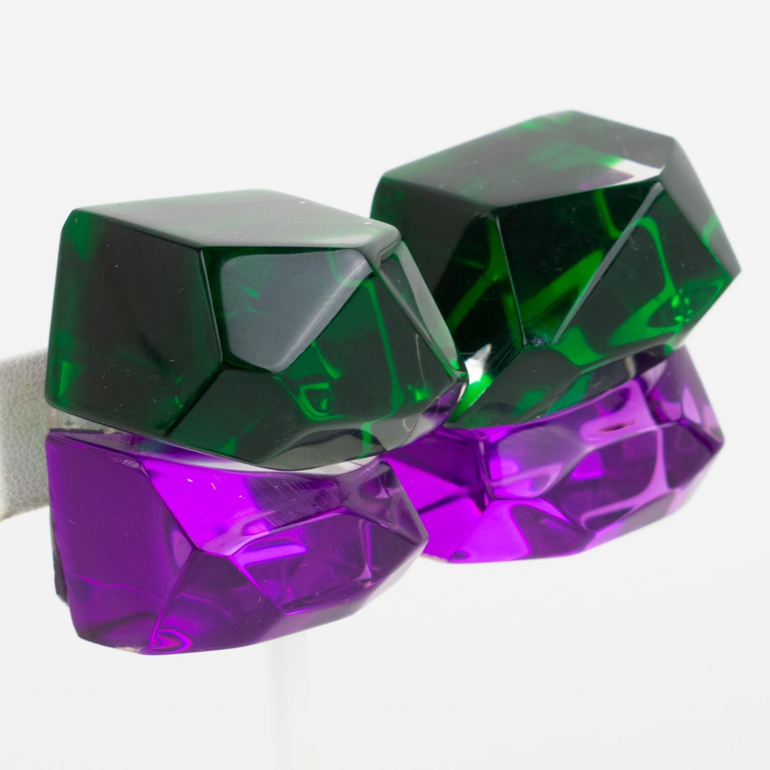 Stunning oversized Lucite clip-on earrings designed by Harriet Bauknight for Kaso. Featuring a huge dimensional double ice cube with amethyst purple and emerald green mirror textured pattern and asymmetric beveled edges all around. 
Kaso paper