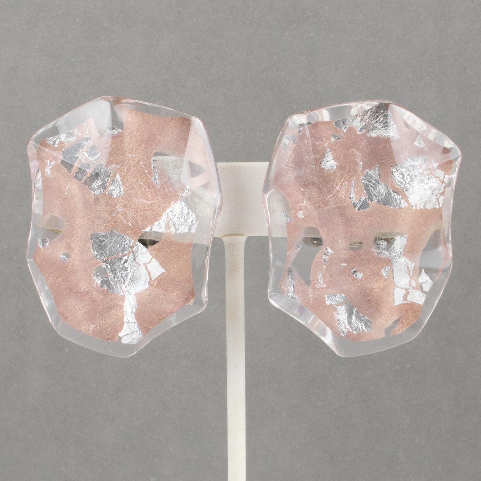 Harriet Bauknight hat für Kaso diese exquisiten Ohrringe aus Lucite entworfen. Die dimensionale Lucite-Kieselsteinform hat ein asymmetrisches Design und eine Abschrägung. Silber- und roségoldfarbene Folieneinschlüsse sind in das klare Lucite