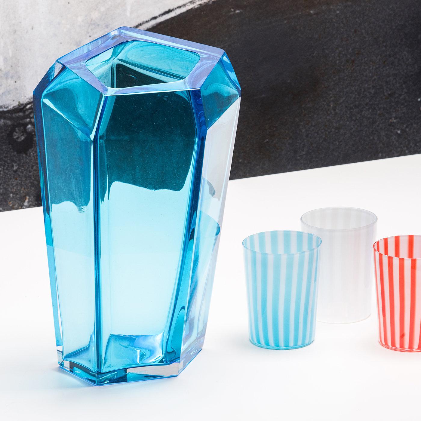 This elegant and modern vase was crafted of mouth-blown Murano glass and designed by Karim Rashid as part of a series of pieces that mix a contemporary sensibility with the exquisite craftsmanship of hand-blowing Murano glass. Tinted with a vivid