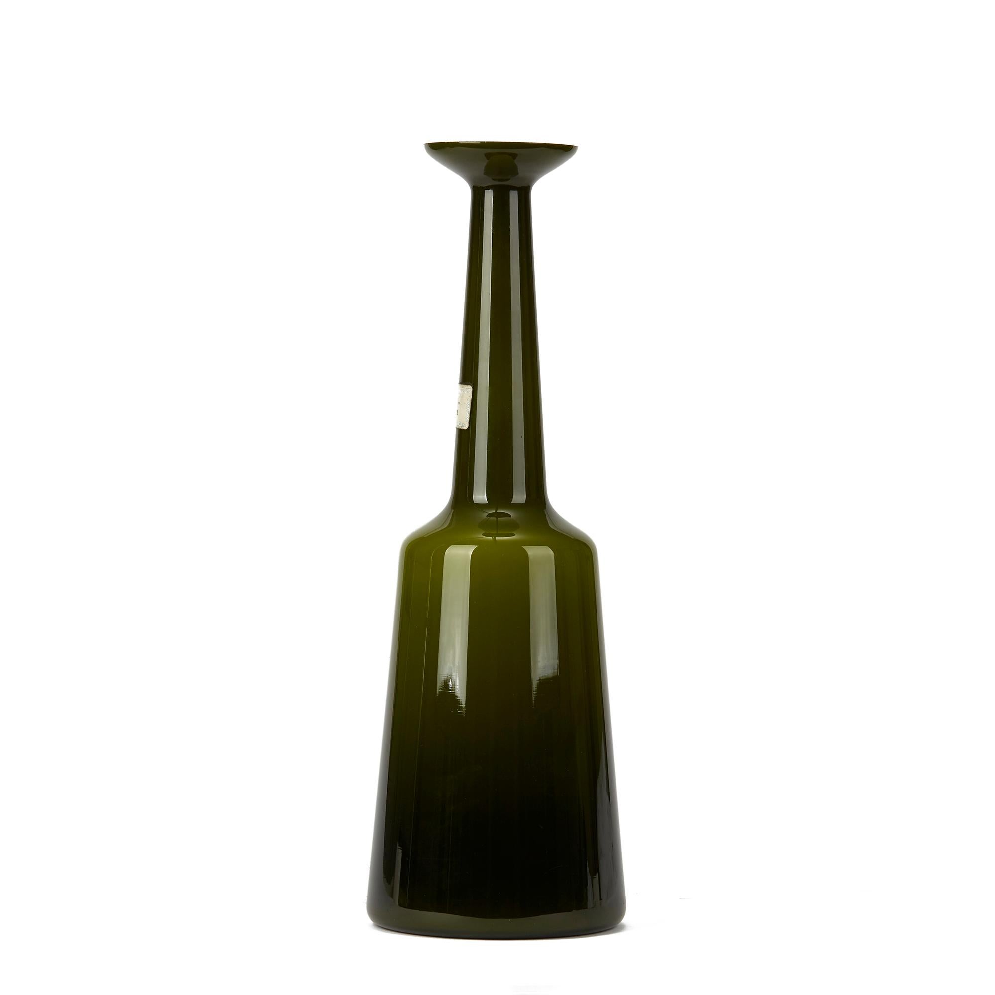 A very rare Danish Kastrup Holmegaard cased glass lamp base cased in green glass with a slightly tapered base leading up to a chimney neck with flared top. The lamp base has an original drilled hole to the lower edge and retains paper labels to the