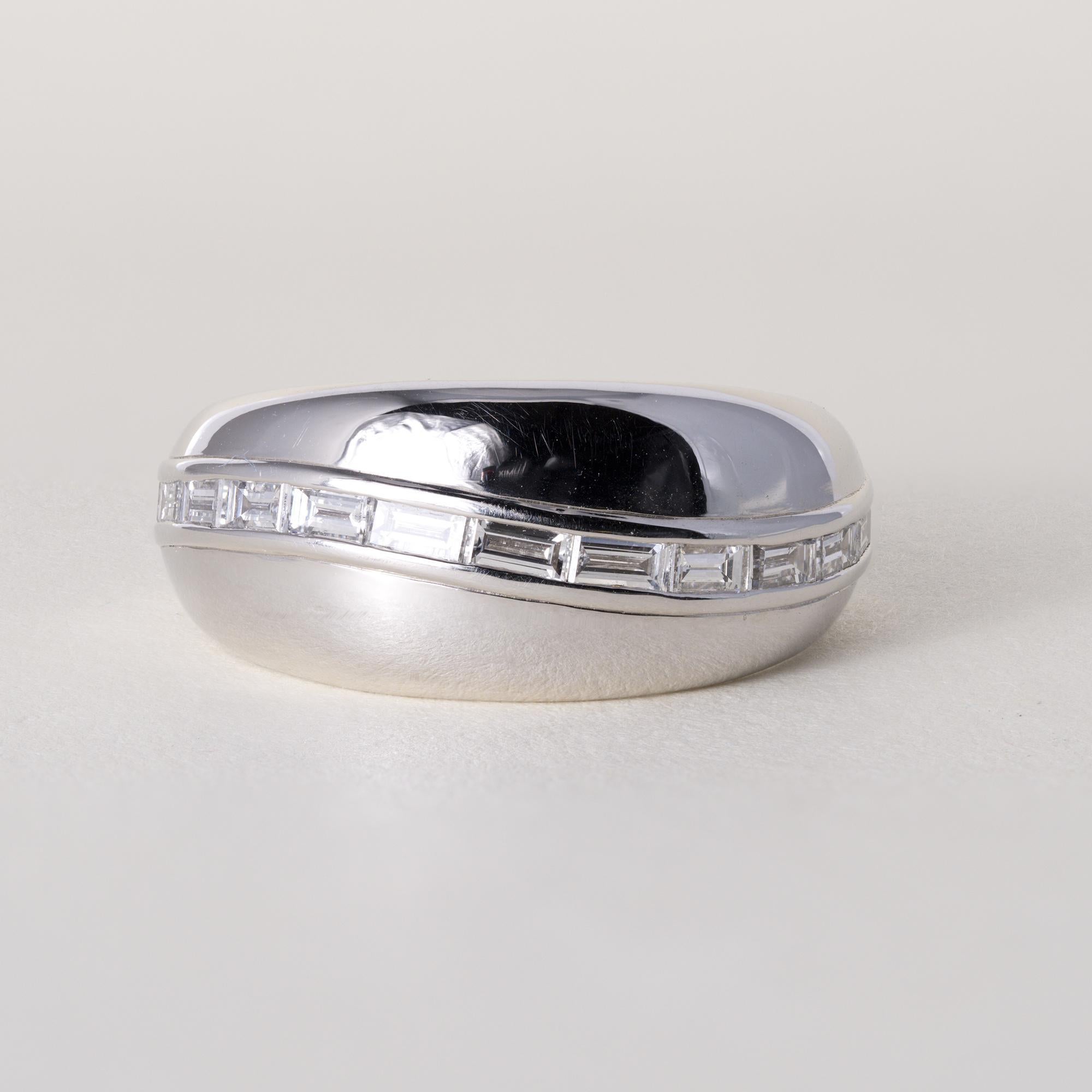 Kat Florence - Fascia con diamanti a baguette incastonati
Questa eccezionale fascia di diamanti di Kat Florence esemplifica la precisione e la maestria della designer.
L'anello è caratterizzato da  diamanti dritti con taglio a baguette, incastonati