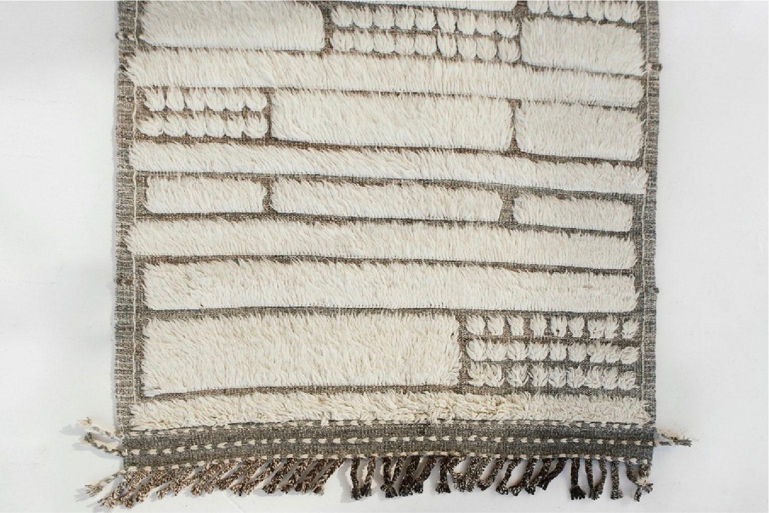 Katabatic is handwoven runner of natural grey/taupe flat-weave with the perfect shade of white shag; embossed detailing. Designed in Los Angeles with immense detail, Katabatic is meant to be lived on and can withstand high amounts of foot