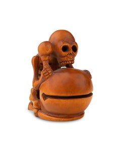 Katabori netsuke in boxwood depicting a skeleton leaning on a drum