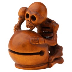 Katabori netsuke in boxwood depicting a skeleton leaning on a drum