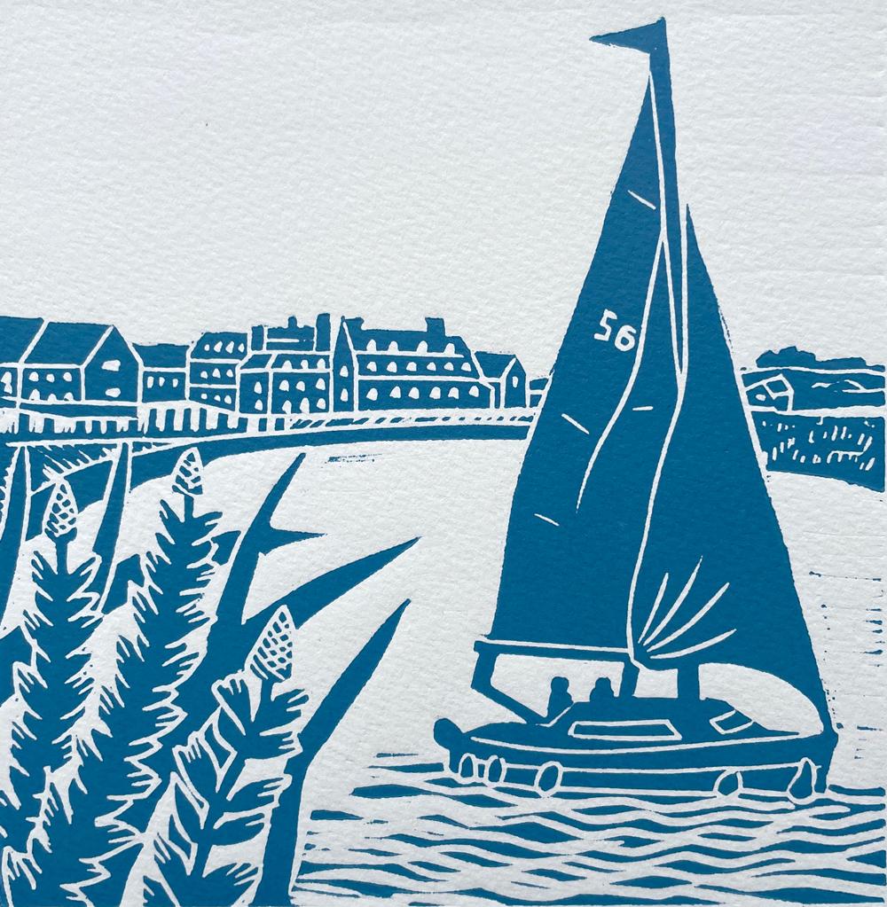 Sailing at high tide at Blakeney, Norfolk with the Blakeney Hotel in the distance at the edge of the quay. Printed in Nautical Blue. Linocut Print – A relief printing technique where linoleum is cut, inked and rolled to create an inverse relief