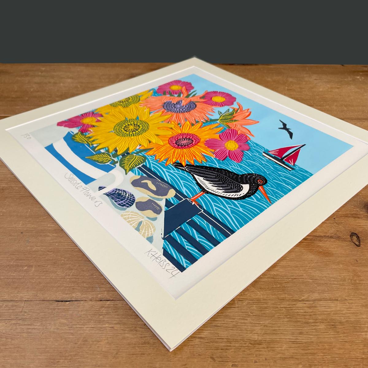 A bunch of cheery sunflowers arranged in a Cornish Ware jug sits pride of place on the window sill of this harbour cottage. A collection of beach finds from the day are laid out on the table and a solitary oystercatcher is perched outside watching
