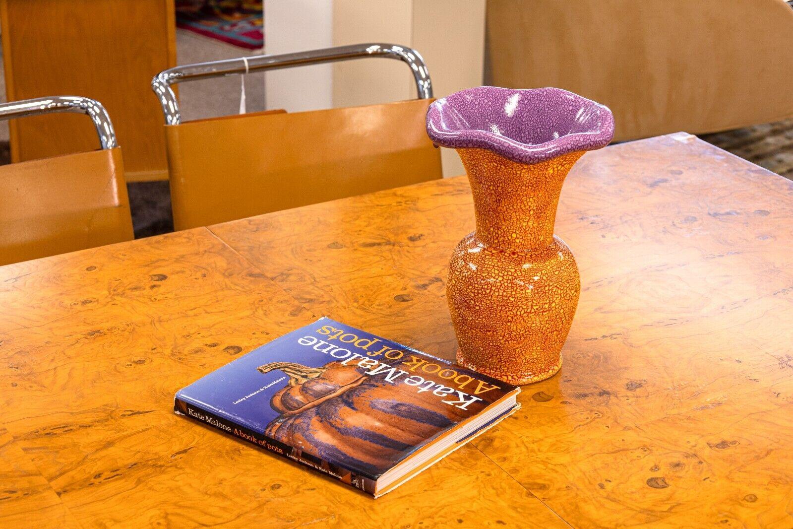 A Kate Malone orange and purple abstract ceramic vase. This is a lovely vase from English ceramist, Kate Malone. Malone is known for her bright sculptural ceramic sculptures with unique glazes and designs. Her work takes great inspiration from