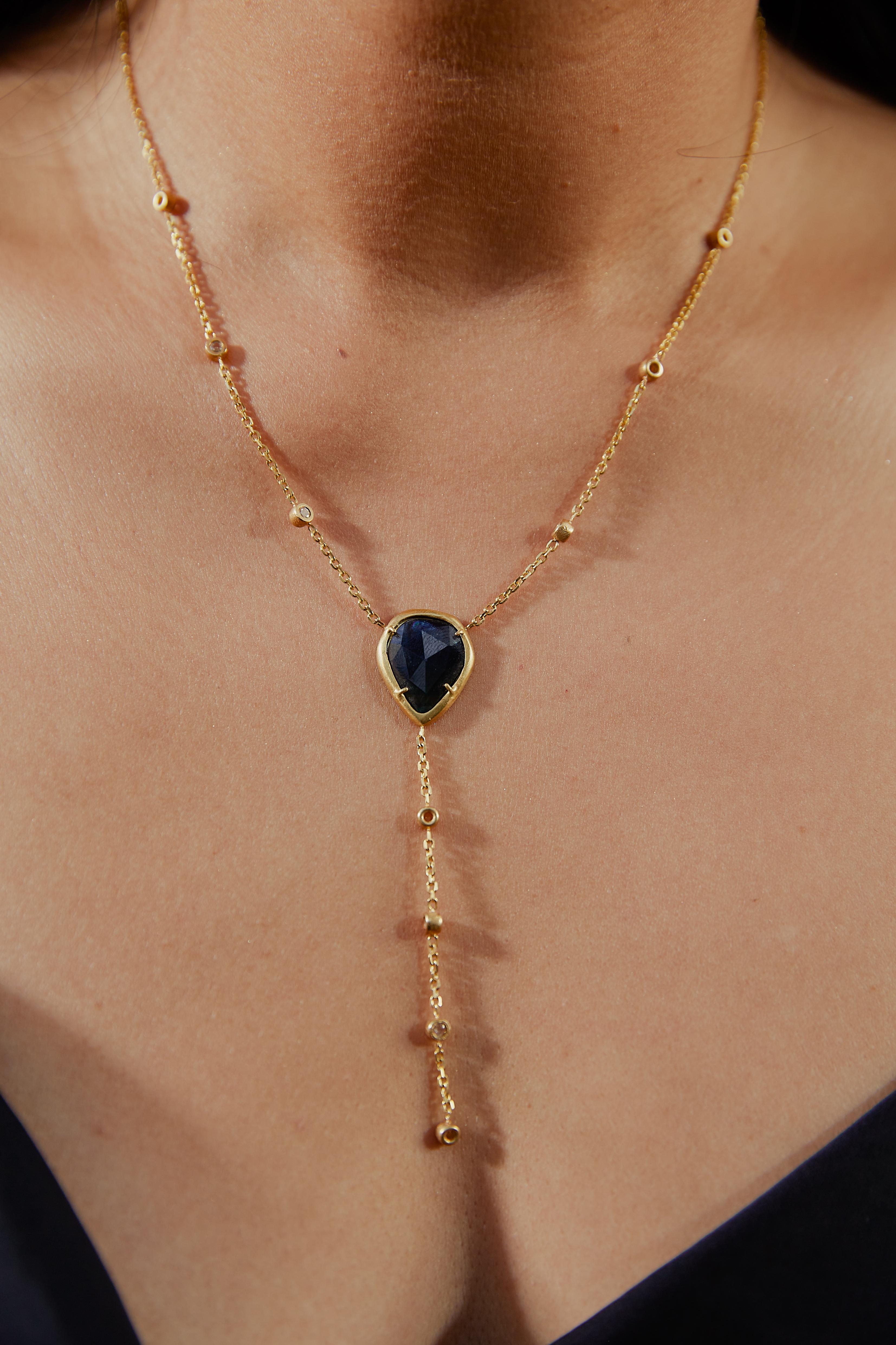The Kate Necklace is a one-of-a-kind lariat-style design, featuring a captivating bi-color rose-cut sapphire as its centerpiece. This 16-inch piece is crafted in 18kt yellow matted gold, with delicate rose-cut white diamond accents elegantly